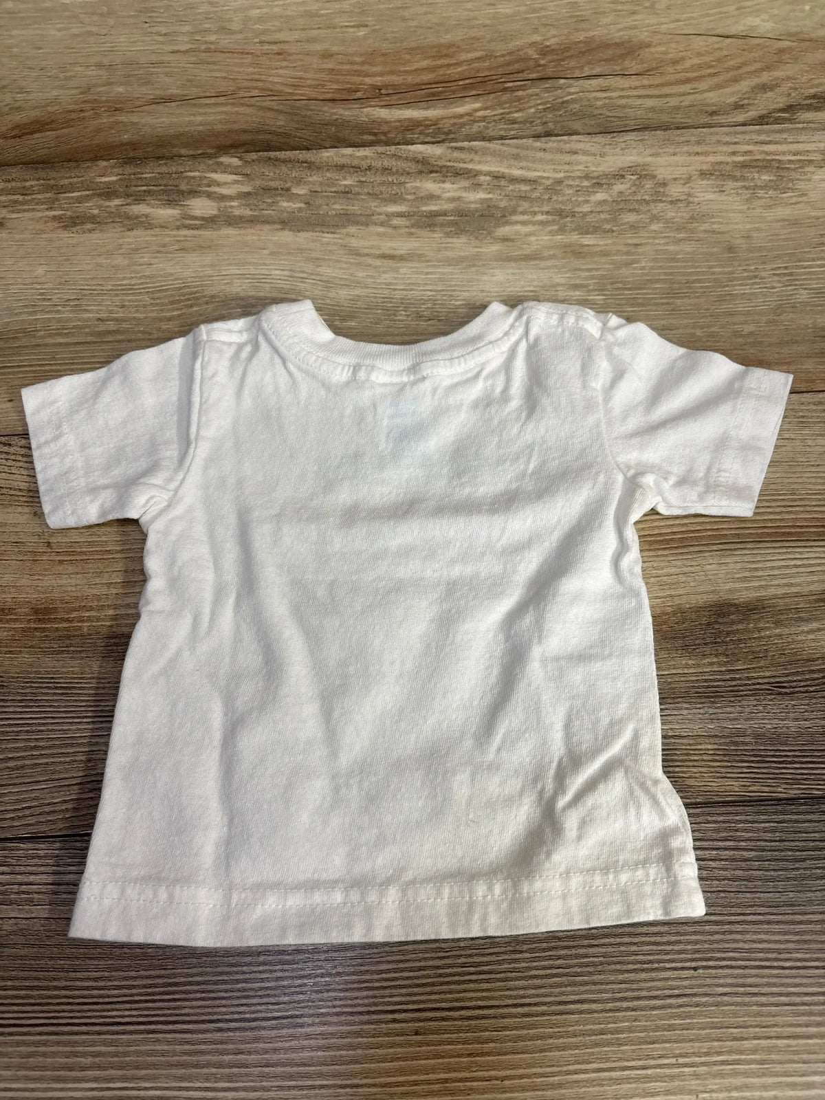 White toddler short sleeve t-shirt on wood floor, kids clothing resale