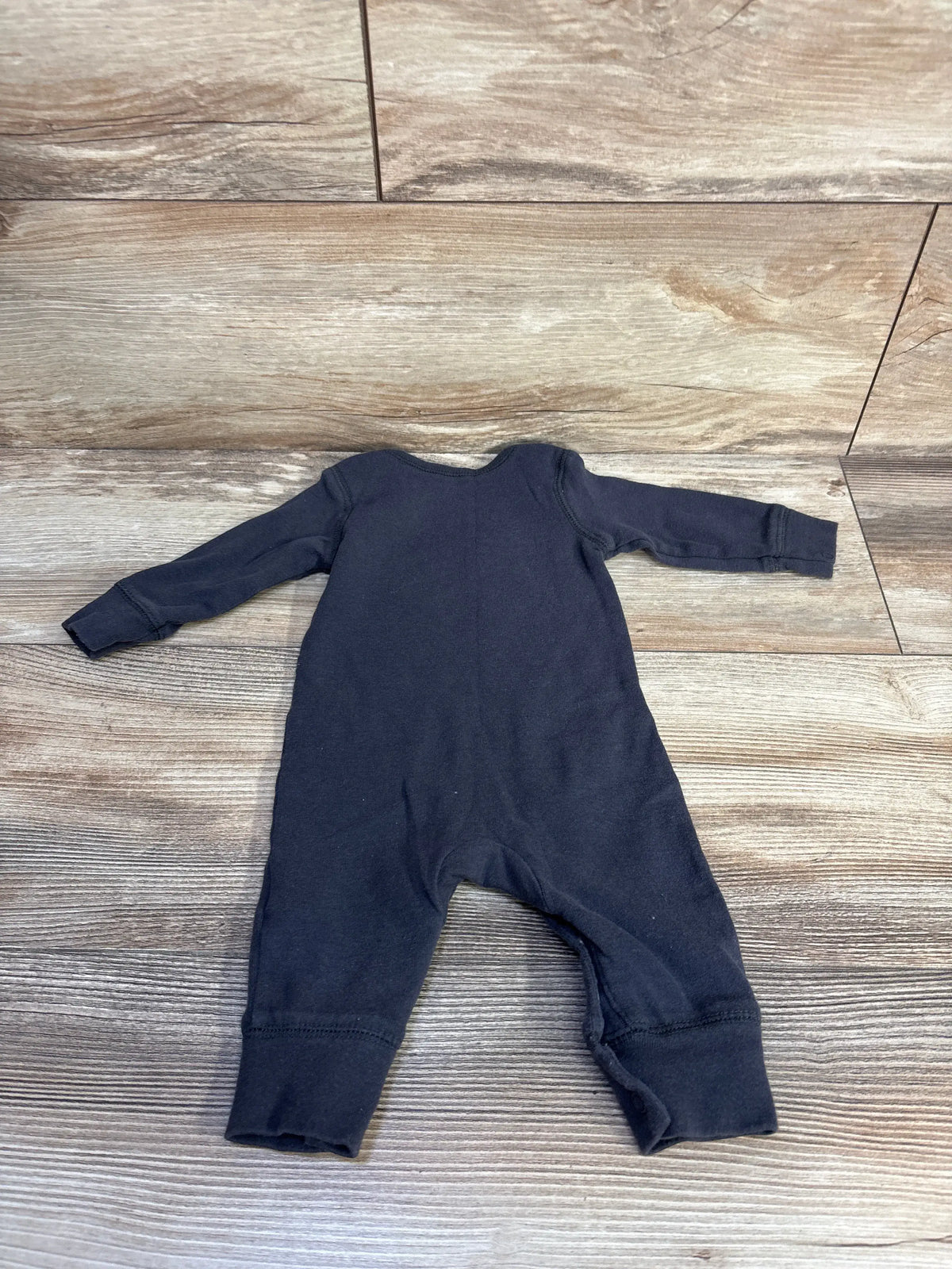 Flat lay of Carter’s grey baby coverall with long sleeves and full-length legs on a wood-look floor