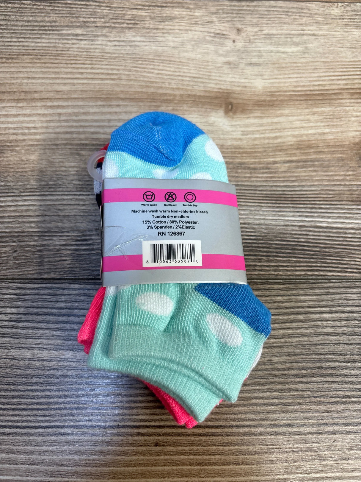 Pack of kids' polka dot socks in blue, mint, and pink on wood background