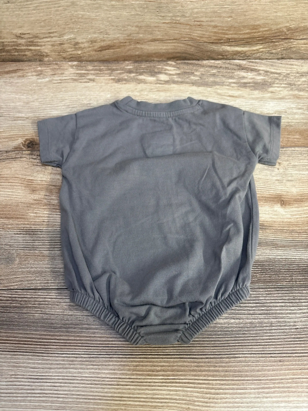 Back view of Cat & Jack Love You More grey romper 0-3 months showing elastic leg openings and short sleeves on wood