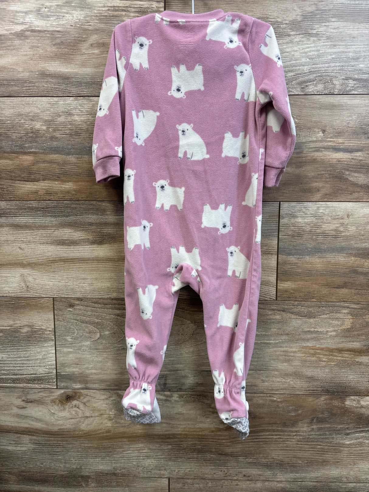 Back view of Carter’s pink blanket sleeper size 18 months showing white polar bear print and footed gripper soles on wood plank background
