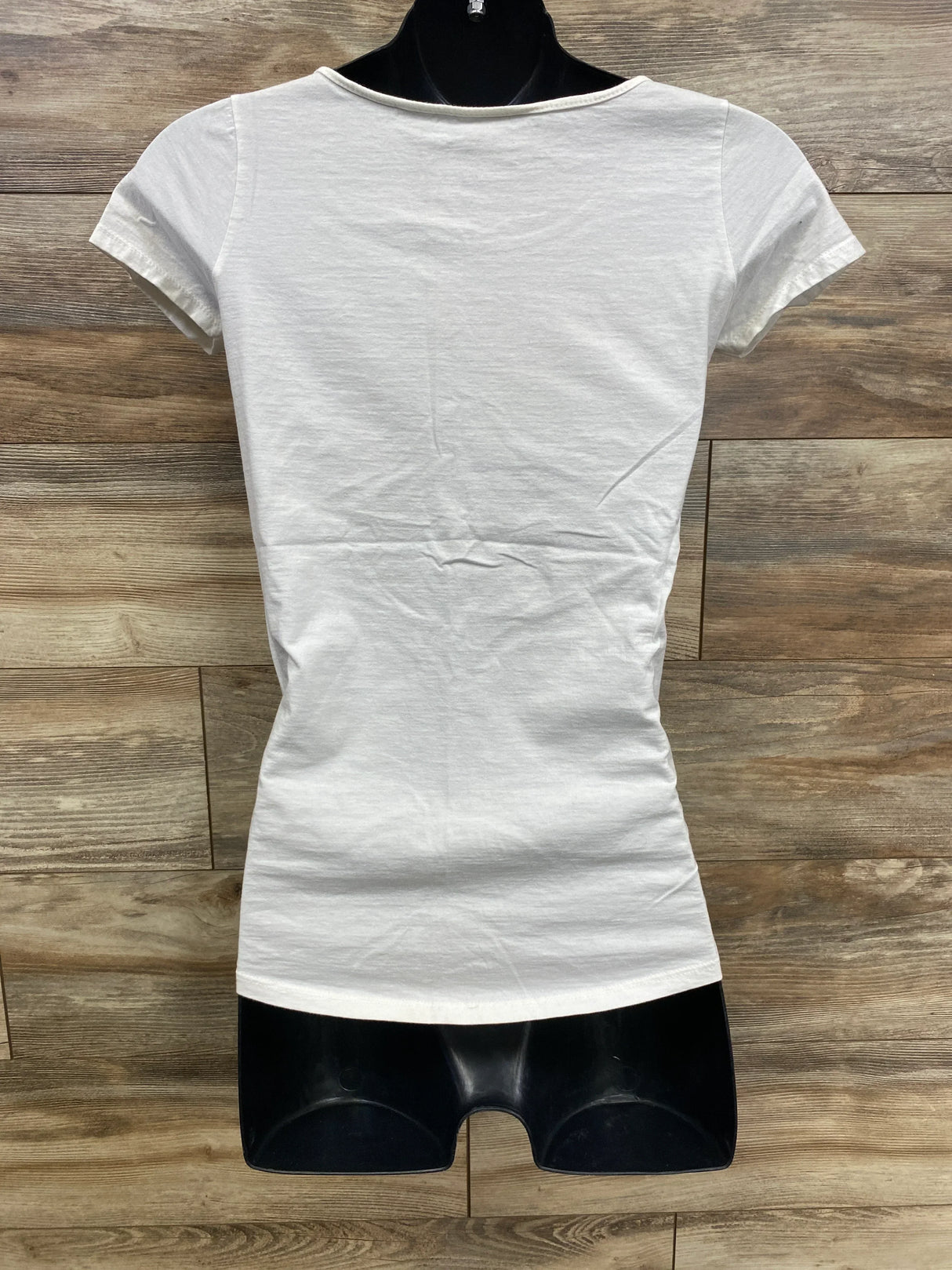 Back view of plain white short-sleeve fitted t-shirt on black mannequin against wooden floor