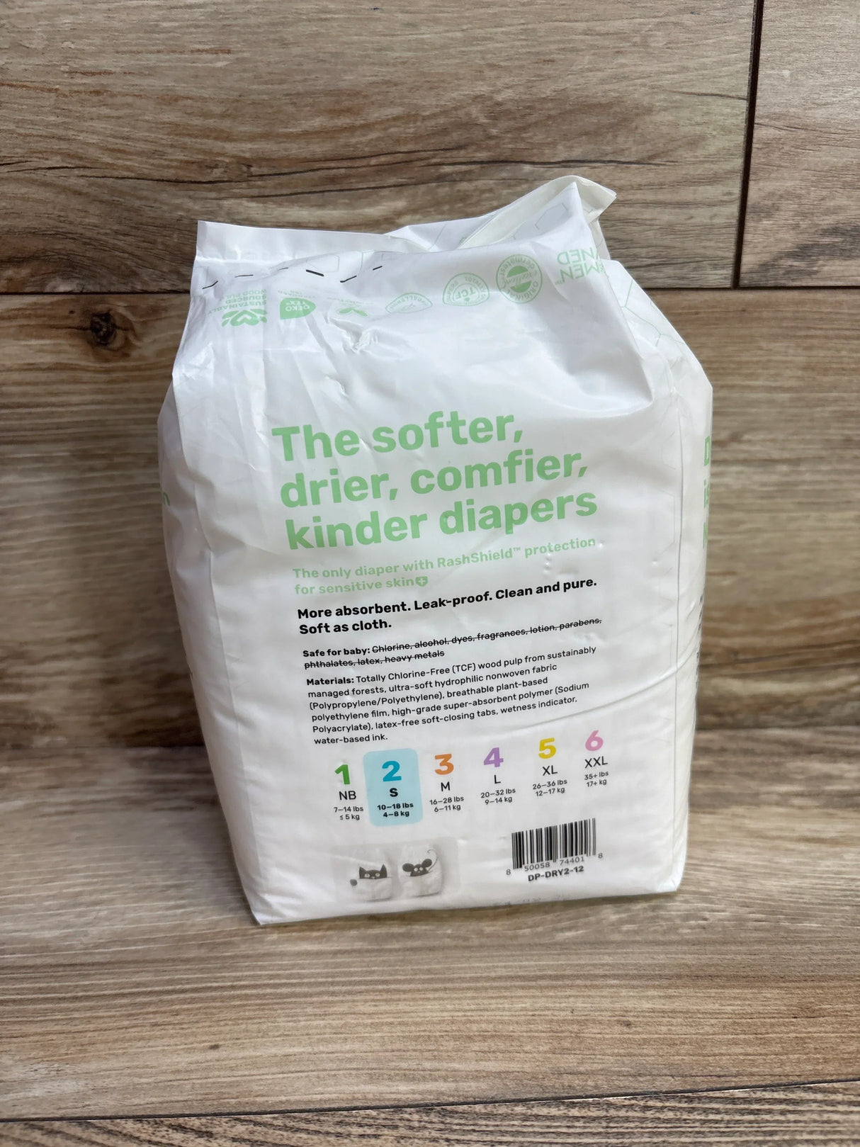 Rear view of Parasol Clear and Dry diaper pack showing headline 'The softer, drier, comfier, kinder diapers' and size 2 icon on wood background