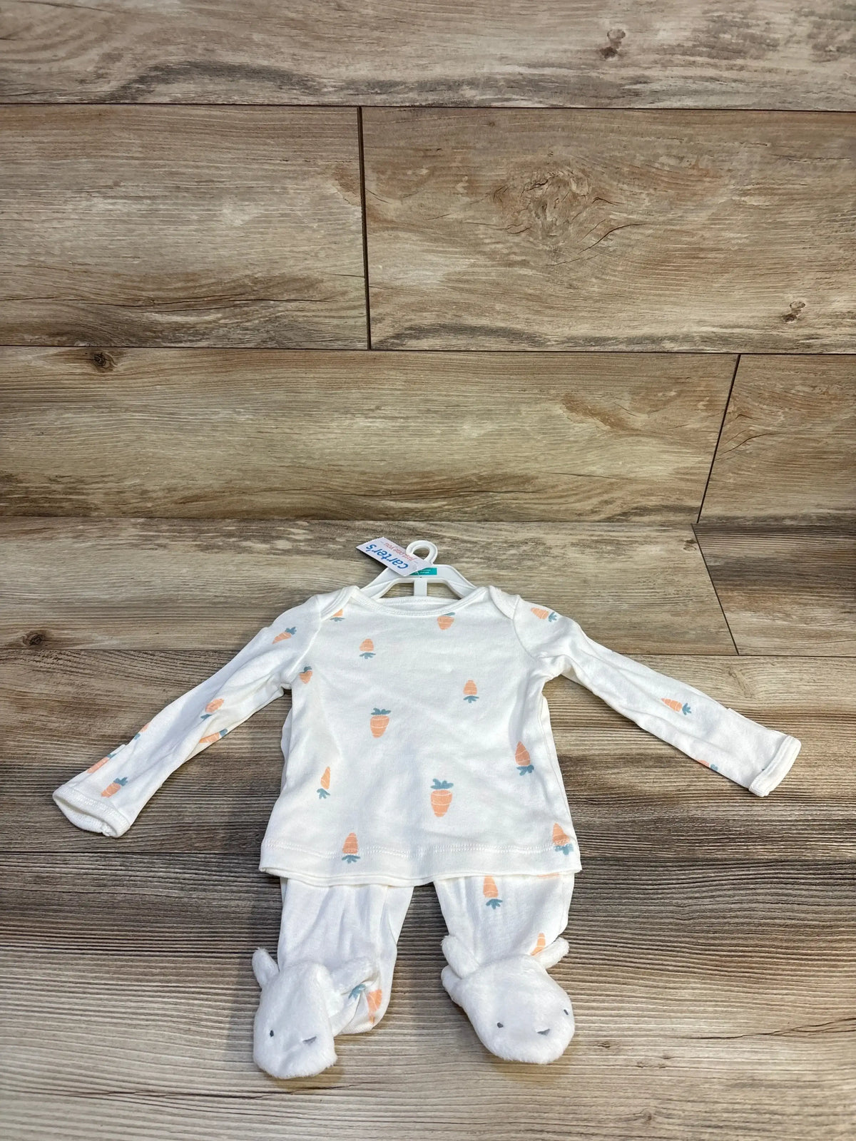 White baby onesie with carrot print and bunny footies on wood floor, Carter's brand