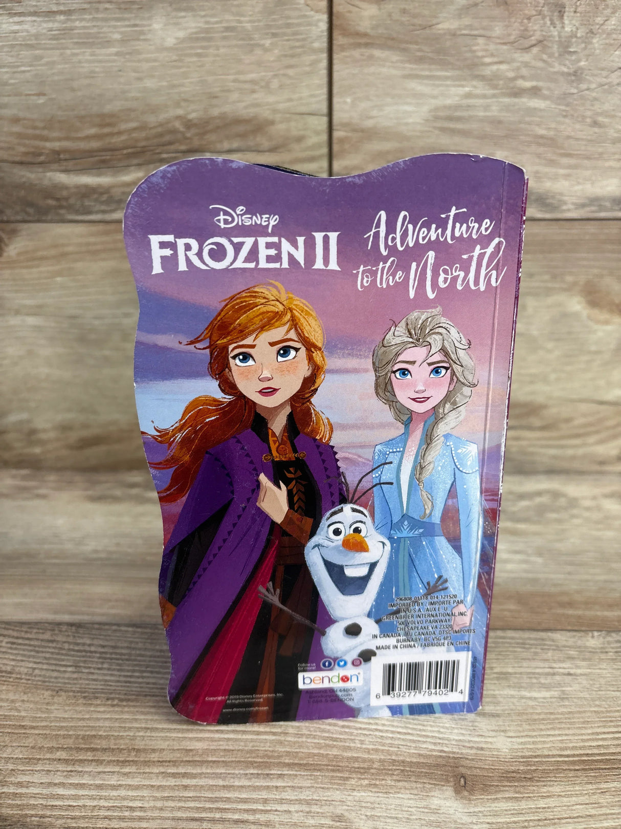 Front cover of Disney Frozen II Adventure to the North board book showing Anna, Elsa, and Olaf on a wooden surface