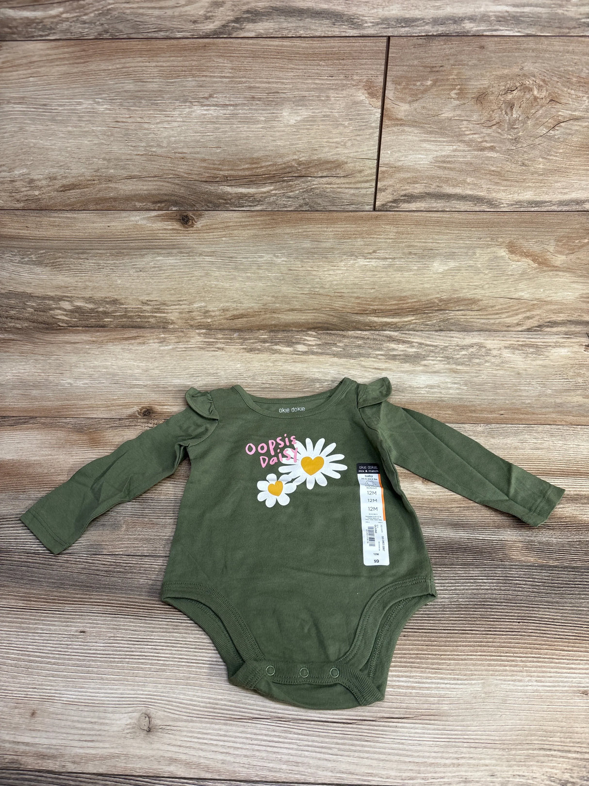 Green Okie Dokie baby bodysuit with ruffle shoulders, daisies graphic, and Oopsie Daisy text, 12 months