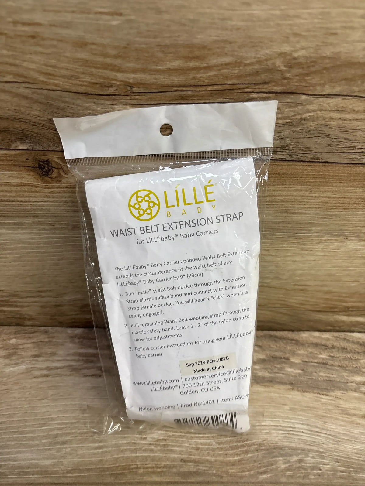 Lillebaby waist belt extension strap for baby carriers in sealed packaging on wood surface
