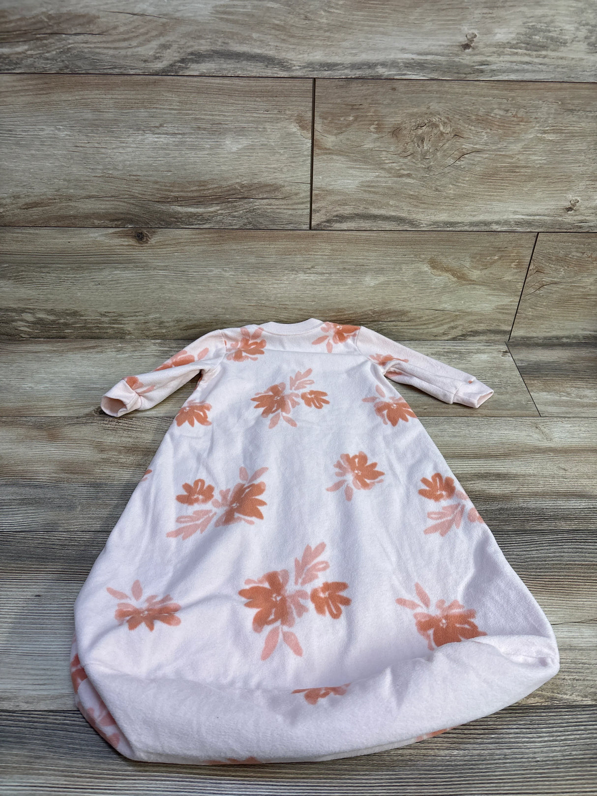 Back view of Carter’s pink blanket sleep sack, size 3-6 months, showcasing coral floral print and long sleeves on wood background