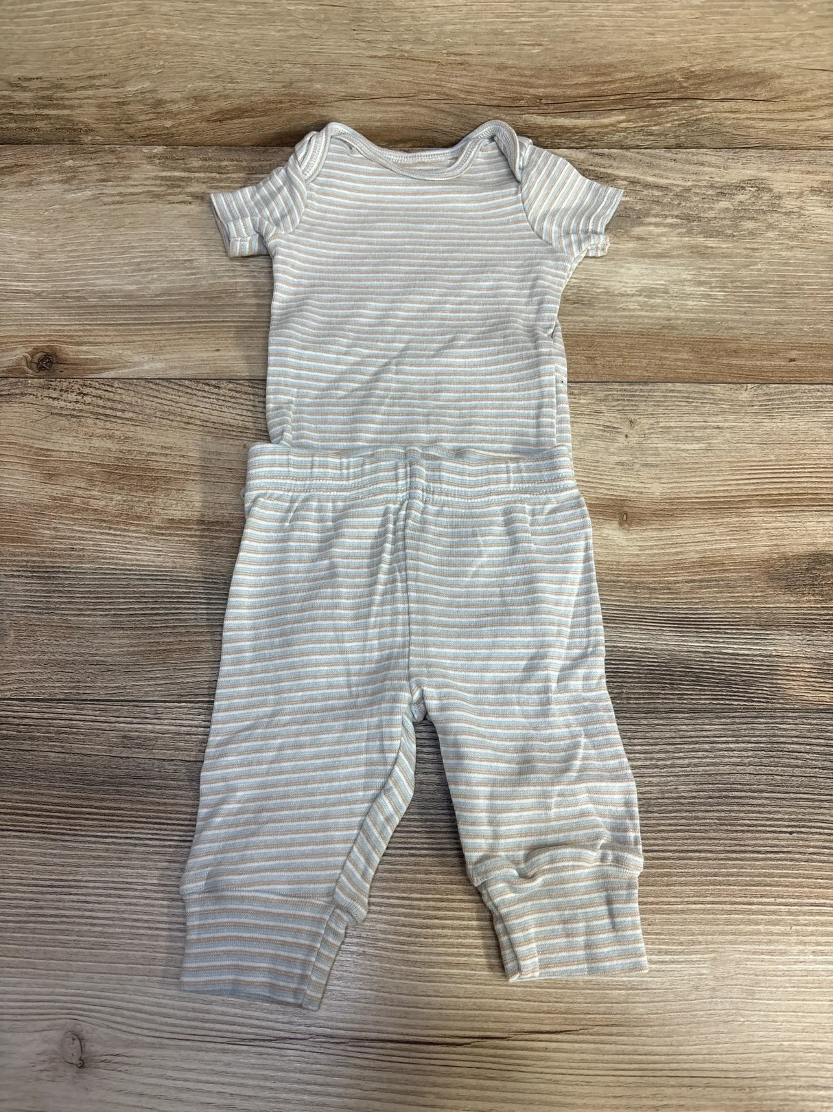 Flat lay of Just One You 2-piece striped short-sleeve baby bodysuit and pants on wood background