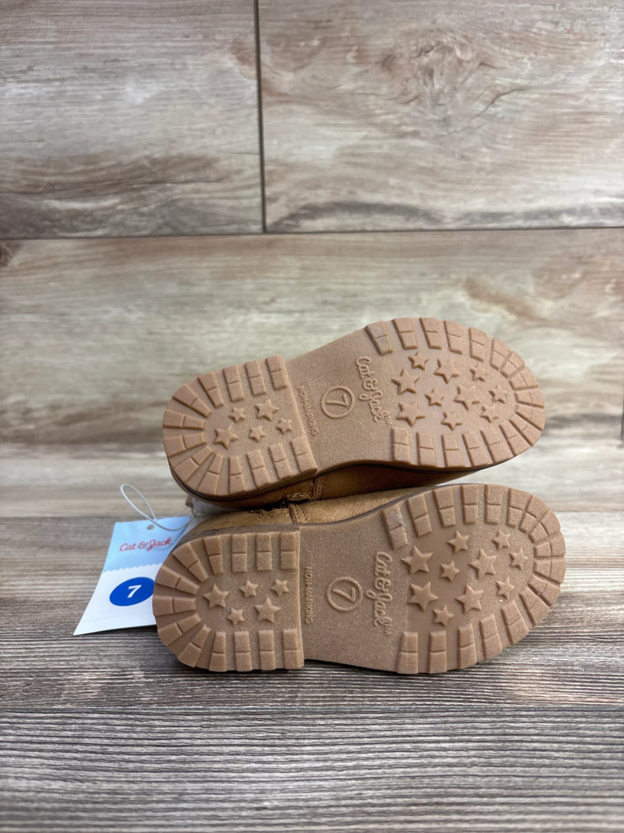 Cat & Jack toddler boots size 7 with star-patterned rubber soles on wood background