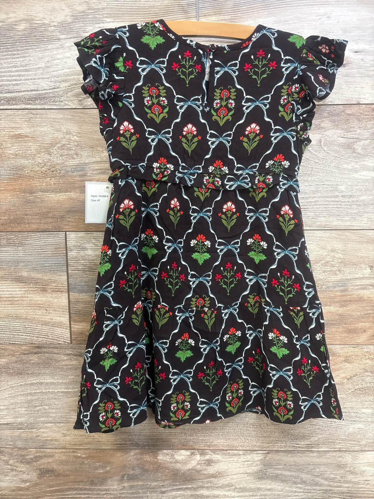 Front view of Lea Kids floral dress in brown, size 4T, showcasing flutter sleeves and floral print on wood-look floor