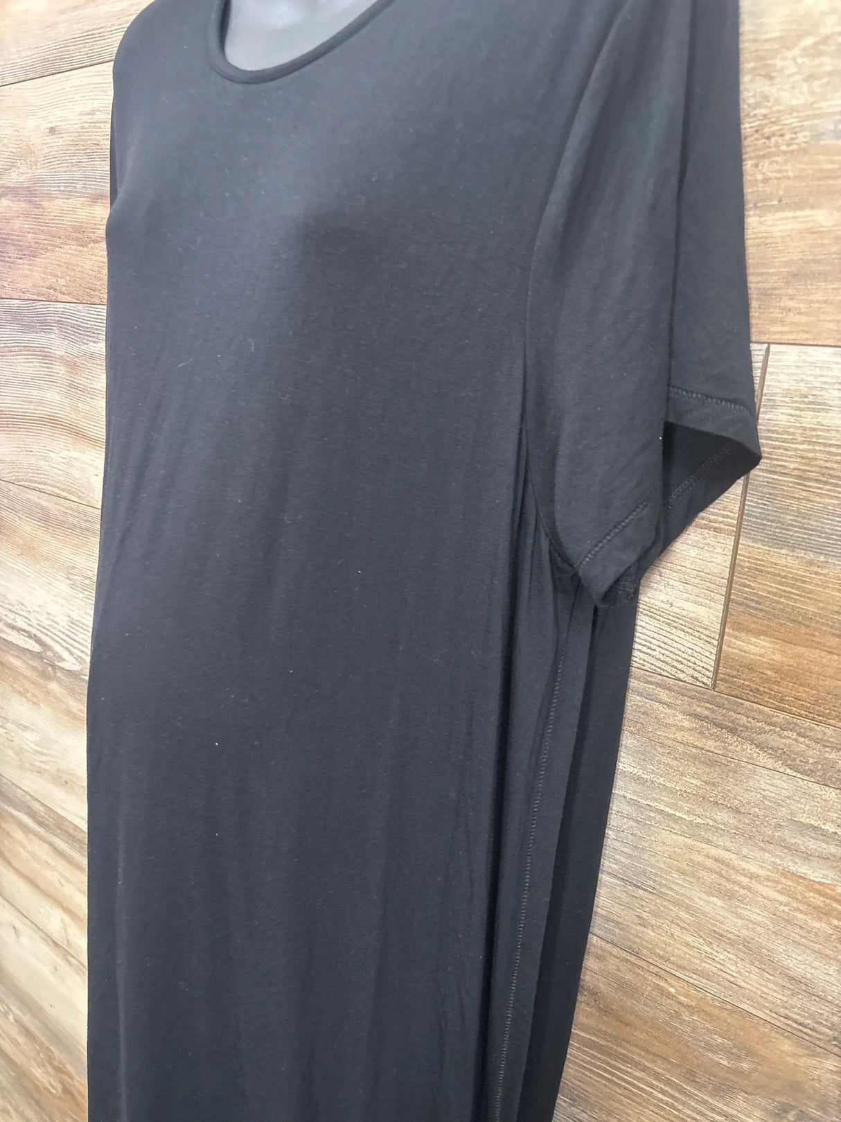 Black maternity t-shirt with short sleeves, displayed on mannequin over wood floor