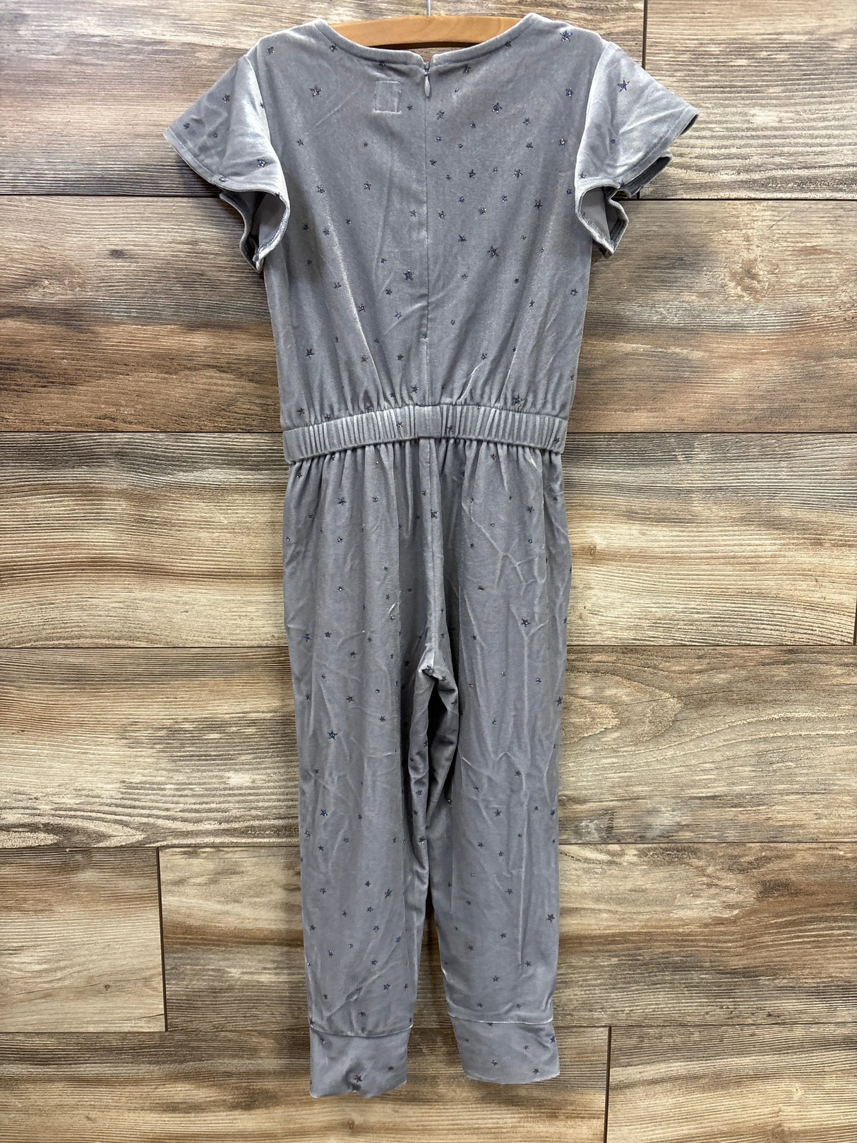 Gray short sleeve star print jumpsuit for kids on wooden background