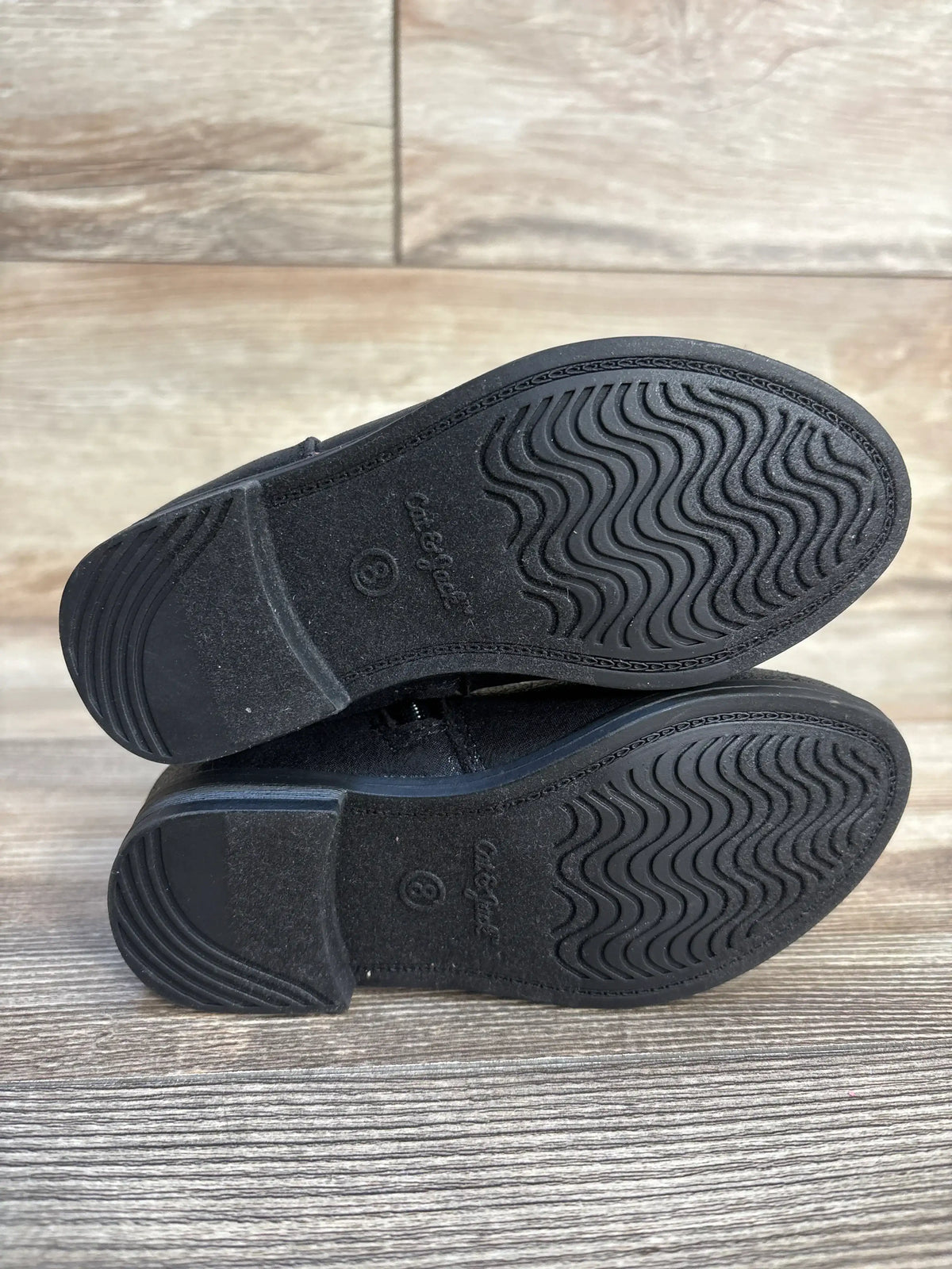 Bottom view of Cat & Jack Sammi toddler ankle boots size 8C showcasing black rubber soles with wavy tread on wood floor