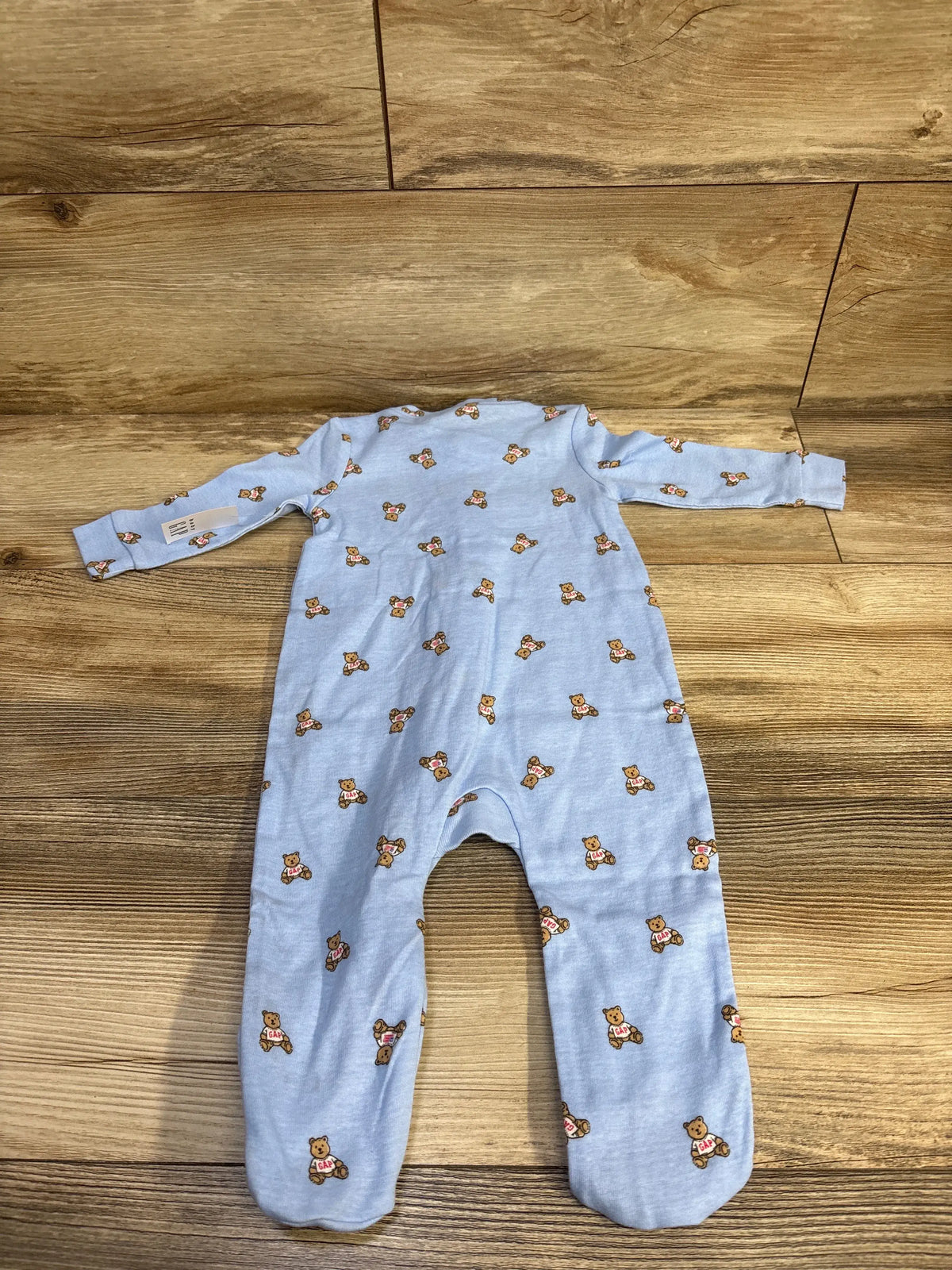 Front view of Baby Gap blue bear print sleeper showcasing long sleeves and full zip design on a wood floor
