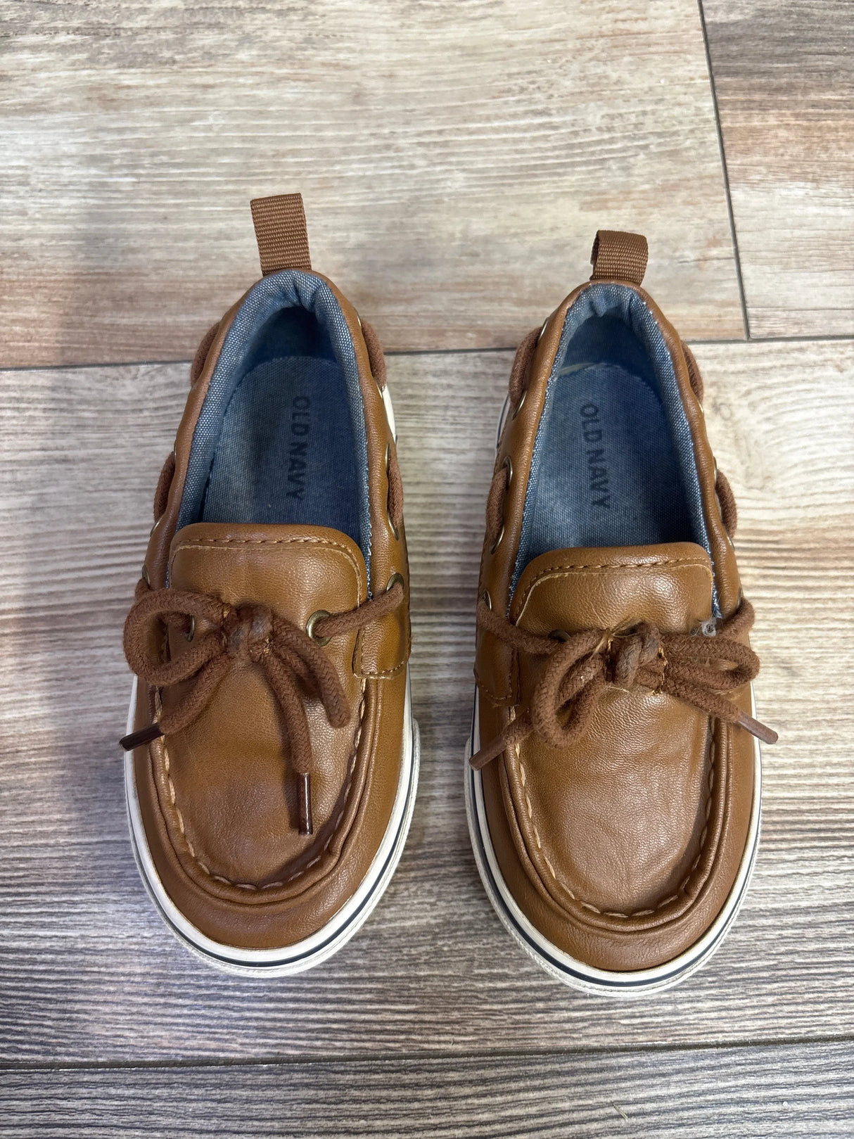 Pair of brown toddler boat shoes with laces on wooden floor, Old Navy brand, kids footwear