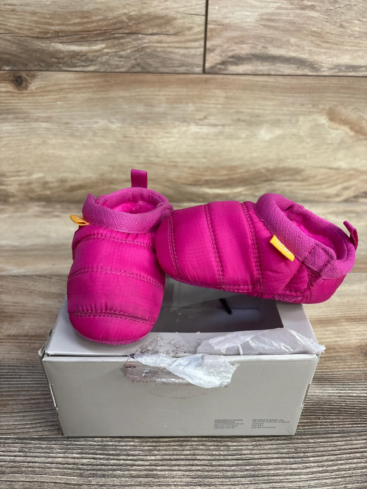 Three quarter view of UGG Tasman LTA baby boots in bright pink showing quilted upper and plush lining on white shoebox
