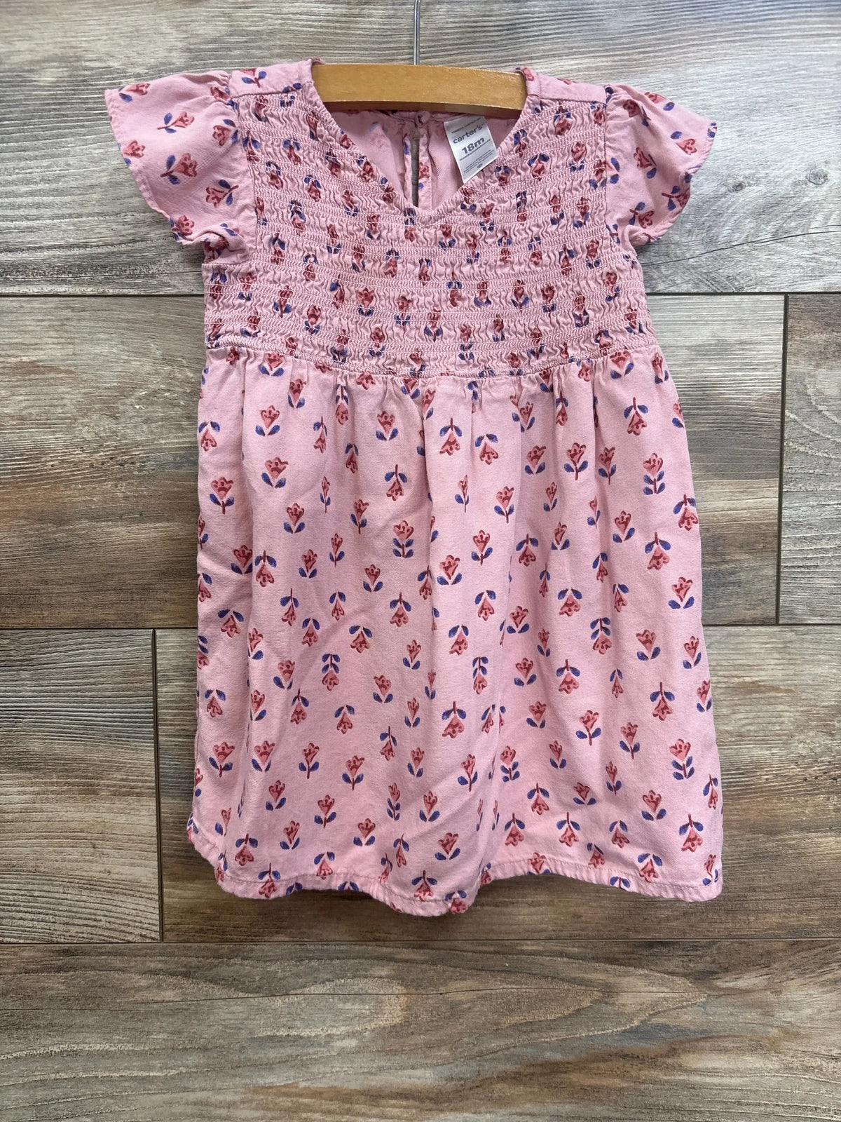 Front view of Carter’s pink floral viscose dress, size 18m, with smocked bodice, cinched waist, and short sleeves