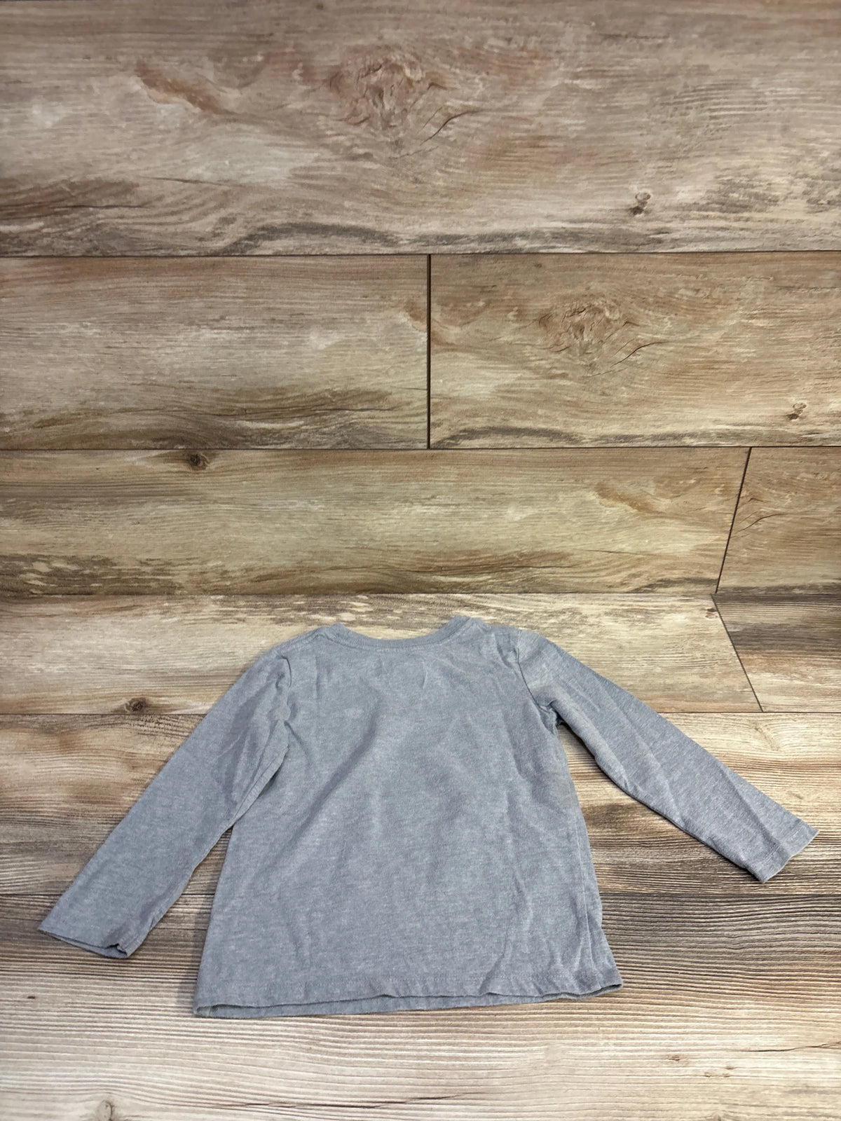 Back view of Cat & Jack toddler long-sleeve grey shirt showcasing crew neckline and flat hem on wood background