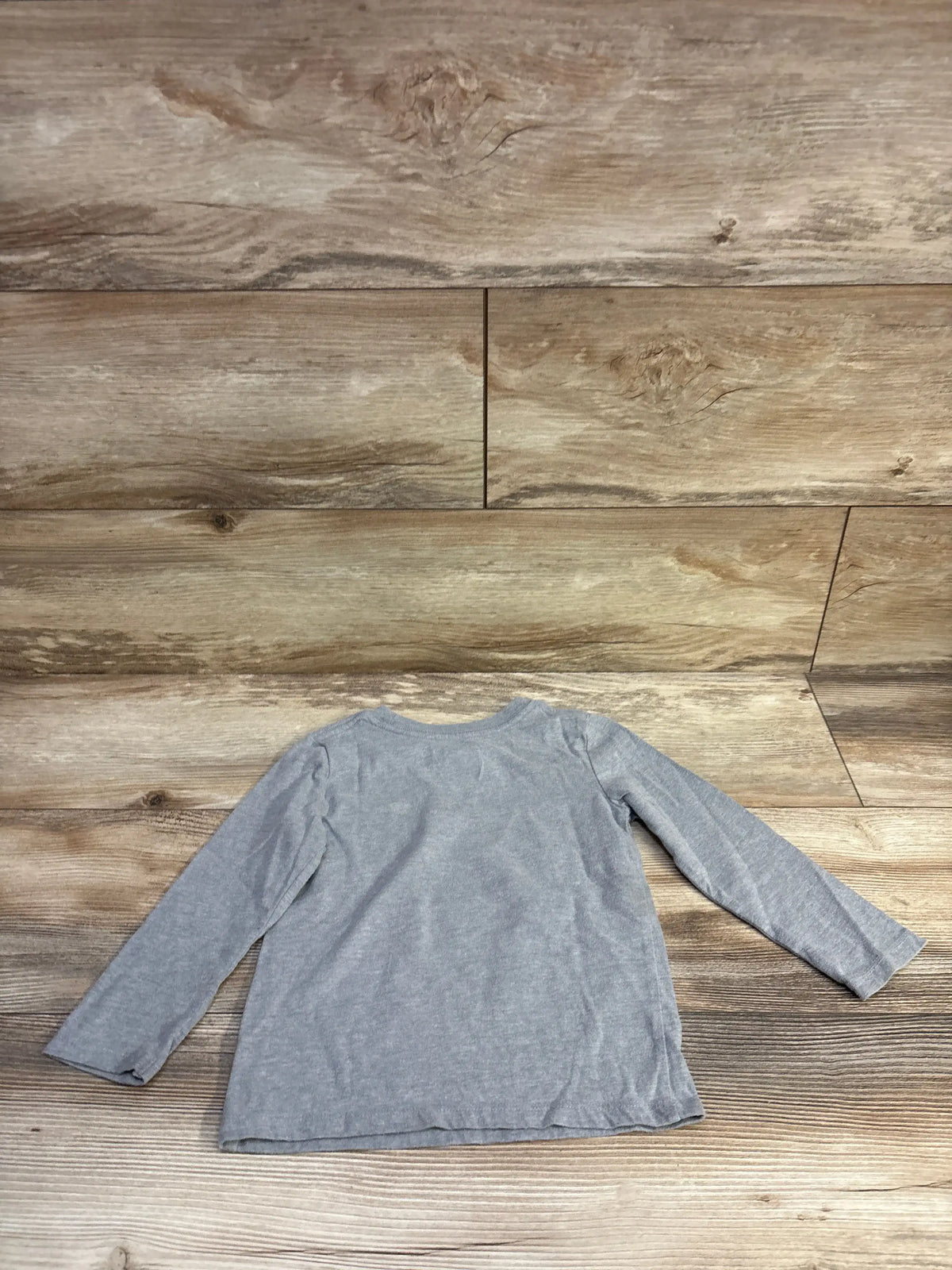 Back view of Cat & Jack toddler long-sleeve grey shirt showcasing crew neckline and flat hem on wood background