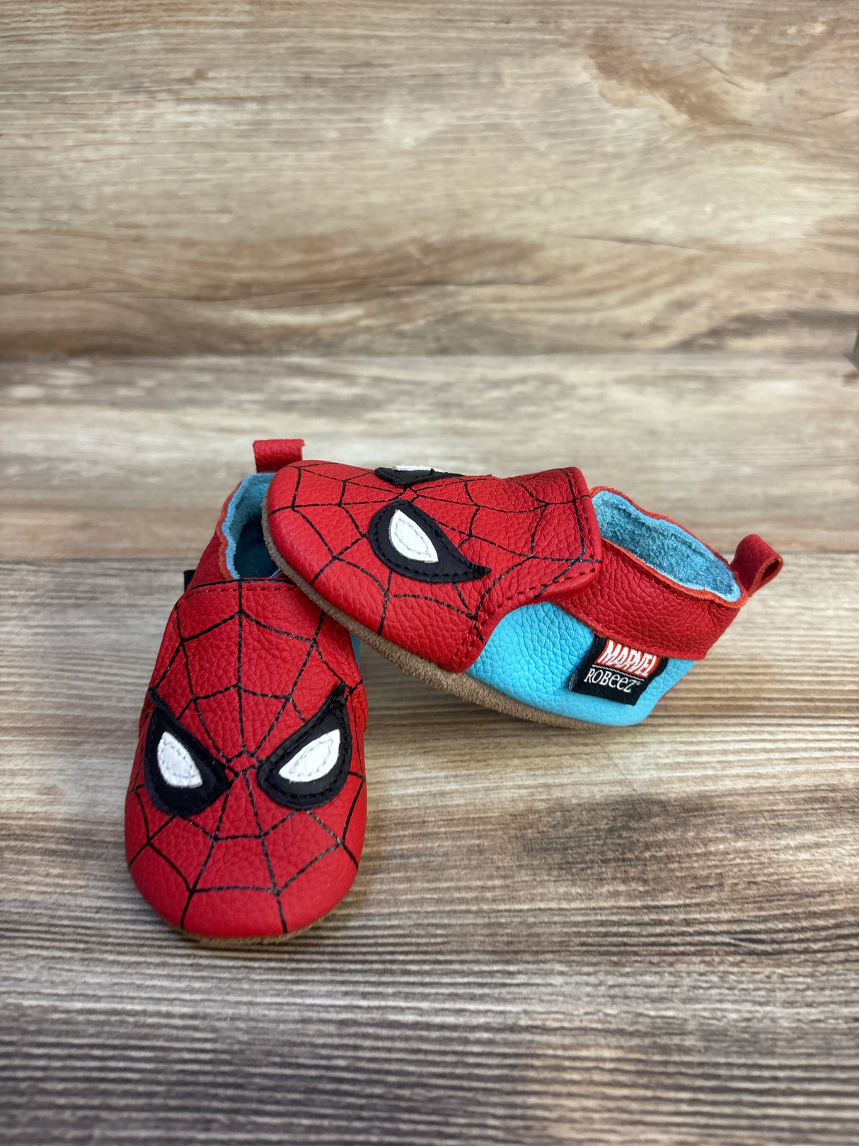 Spider-Man baby shoes with red web design and blue accents, soft sole for infants