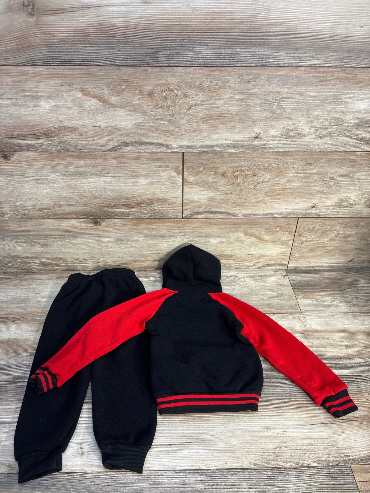 Back view of black Victory League Chicago 23 sweatshirt and joggers set showing red sleeves and striped cuffs