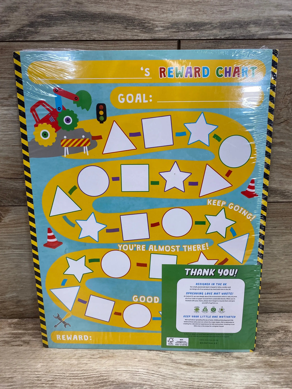 Front view of NEW Central.23 reward chart for kids showcasing a yellow winding path of blank shape stickers, ‘Goal:’ header and thank-you sticker on wood background