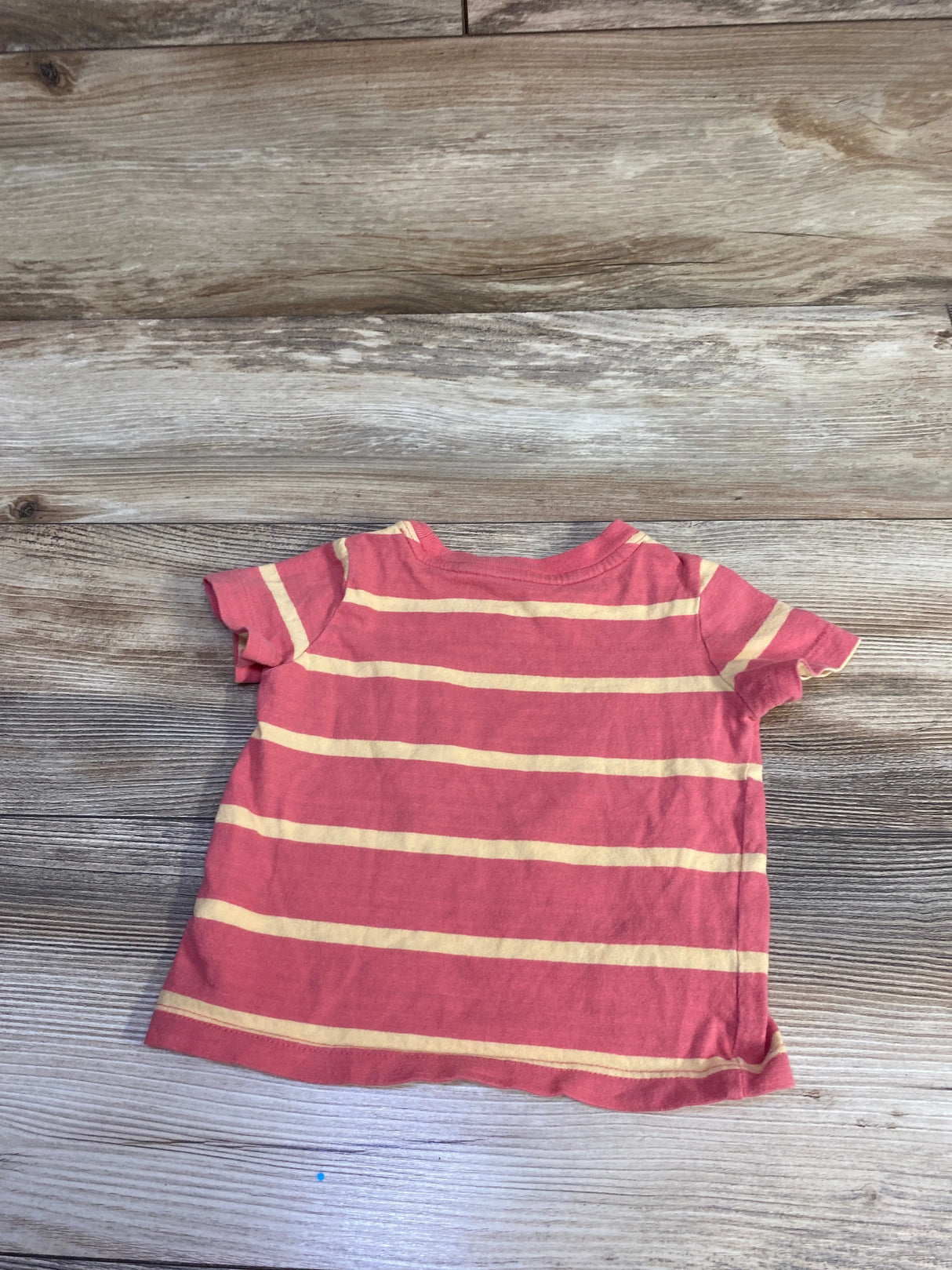 Back view of Baby Gap short-sleeve tee showing red with pale yellow horizontal stripes on wood background