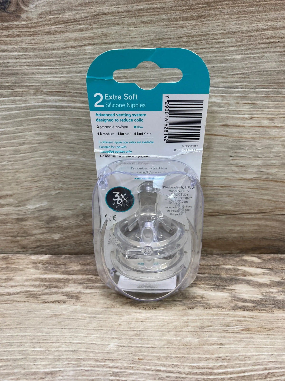 Front view of Nanobebe 2 Extra Soft slow-flow silicone nipples 2-pack in clear blister packaging on a light wood background