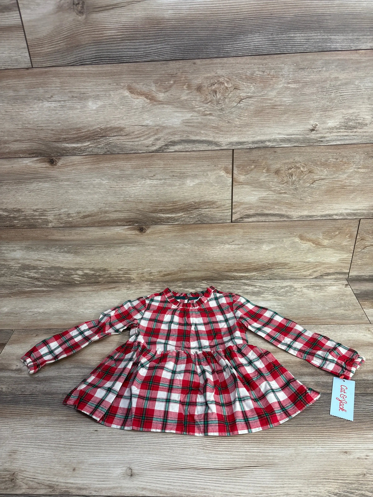 Red and white plaid long-sleeve toddler dress with ruffled collar on wood floor