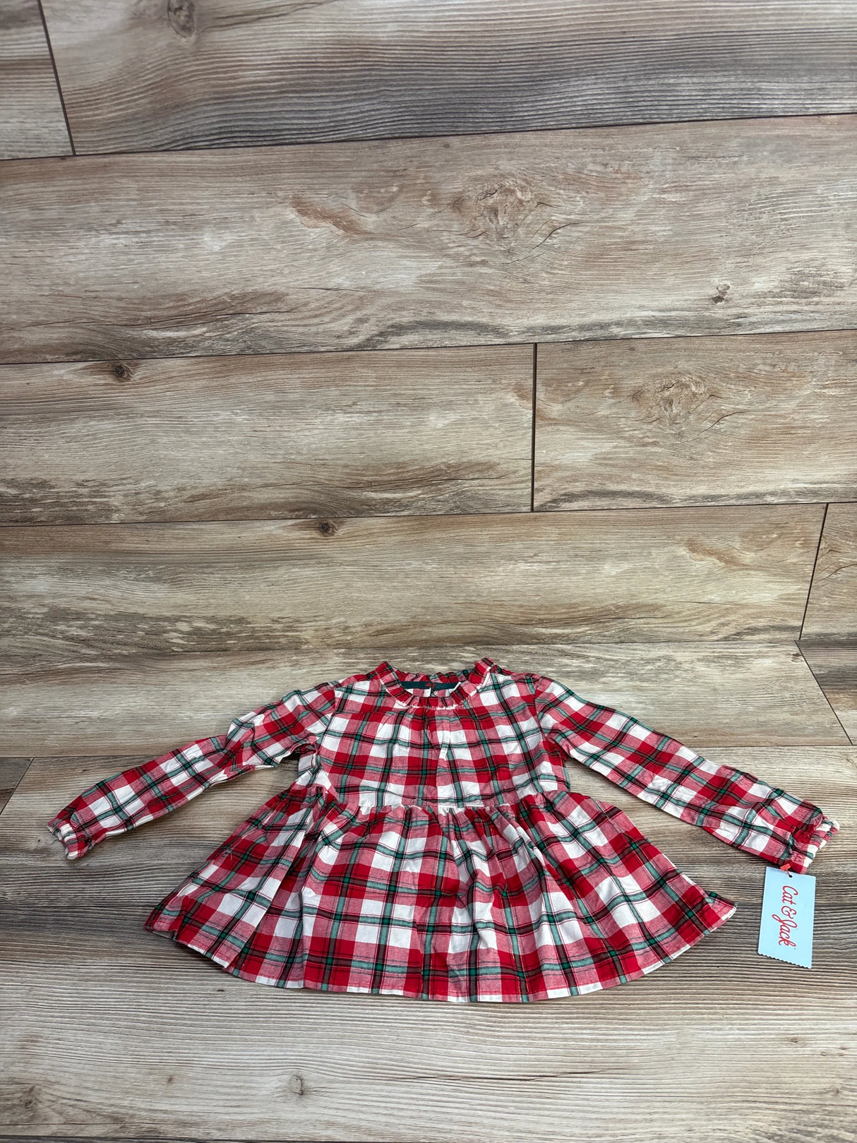 Red and white plaid long-sleeve toddler dress with ruffled collar on wood floor