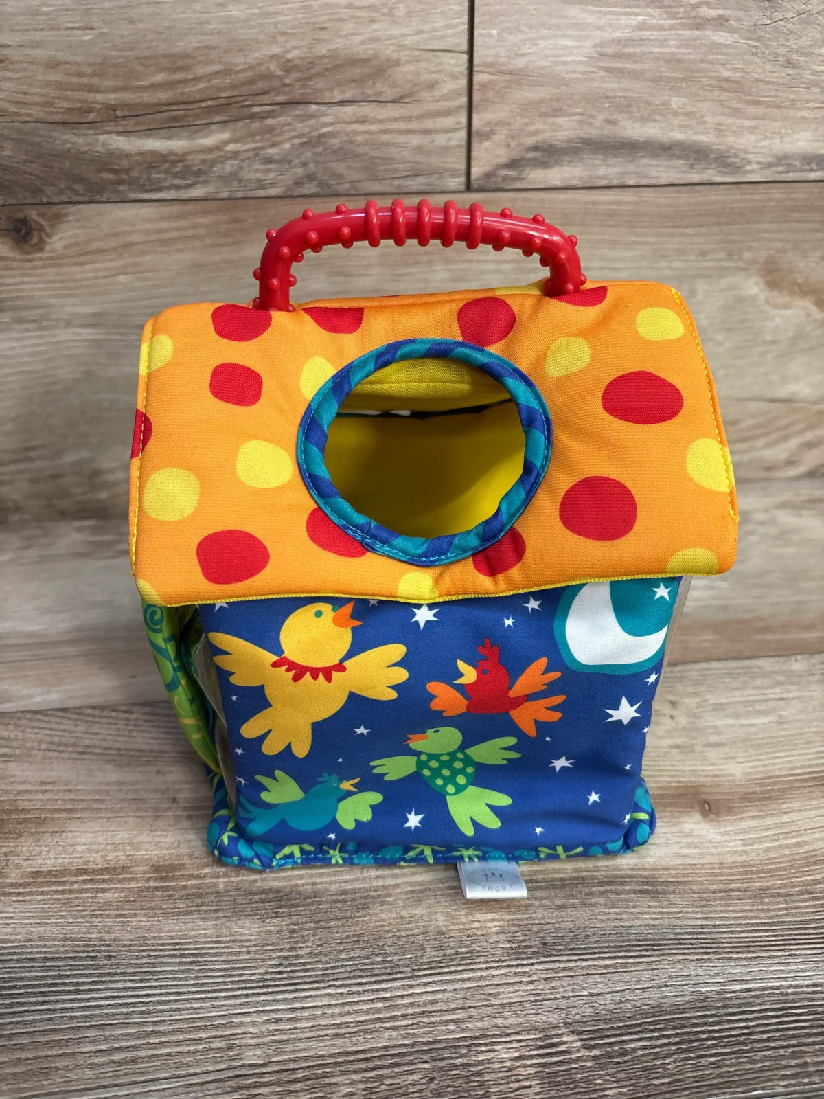 Colorful soft toy birdhouse with polka dot roof and playful bird prints on wood floor