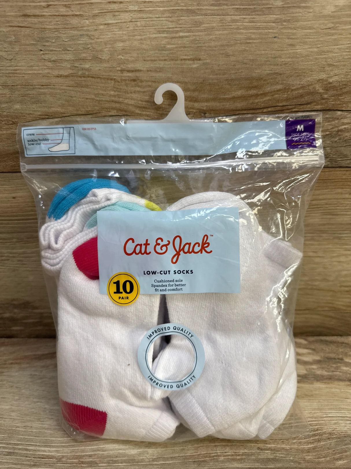 Front view of 10-pack Cat and Jack low-cut toddler socks size M showing white socks with colored heel accents in clear packaging on wood