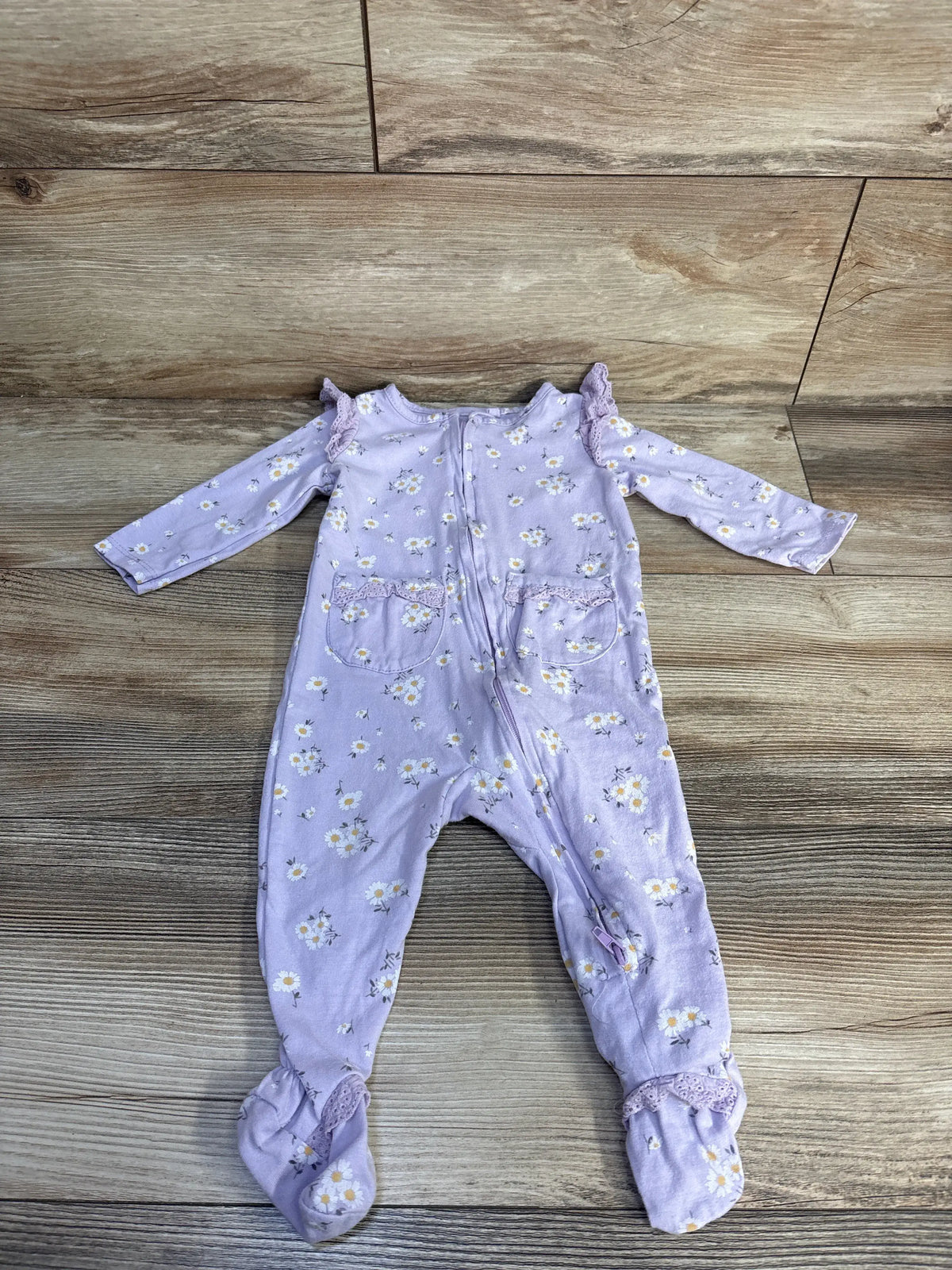 Front view of a purple Jessica Simpson floral sleeper showcasing long sleeves ruffled trim front pockets and footed legs