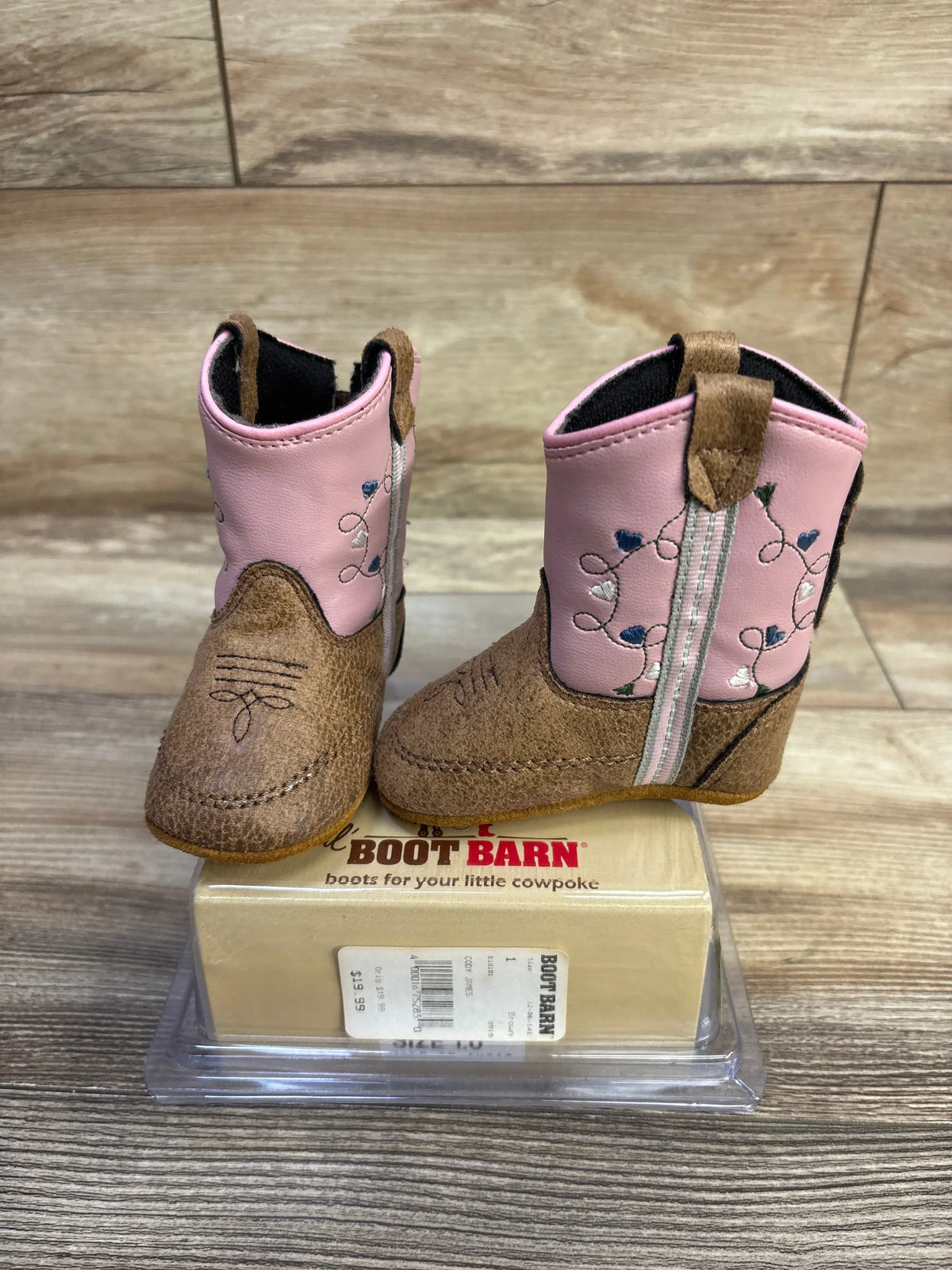 Angled view of Old West Poppets toddler boots showing pink embroidered shaft and brown faux suede toe on wood background