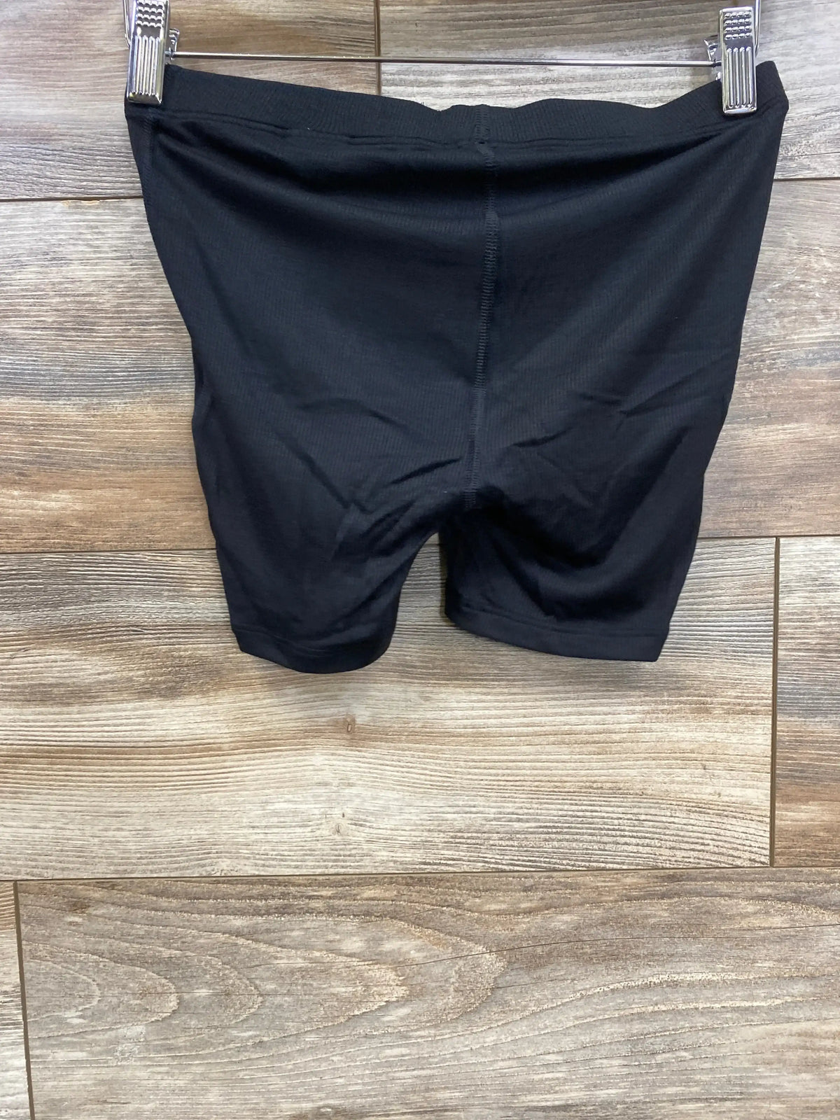 Front view of black Gap maternity rib PJ shorts showcasing ribbed fabric and high-stretch waistband against wood background