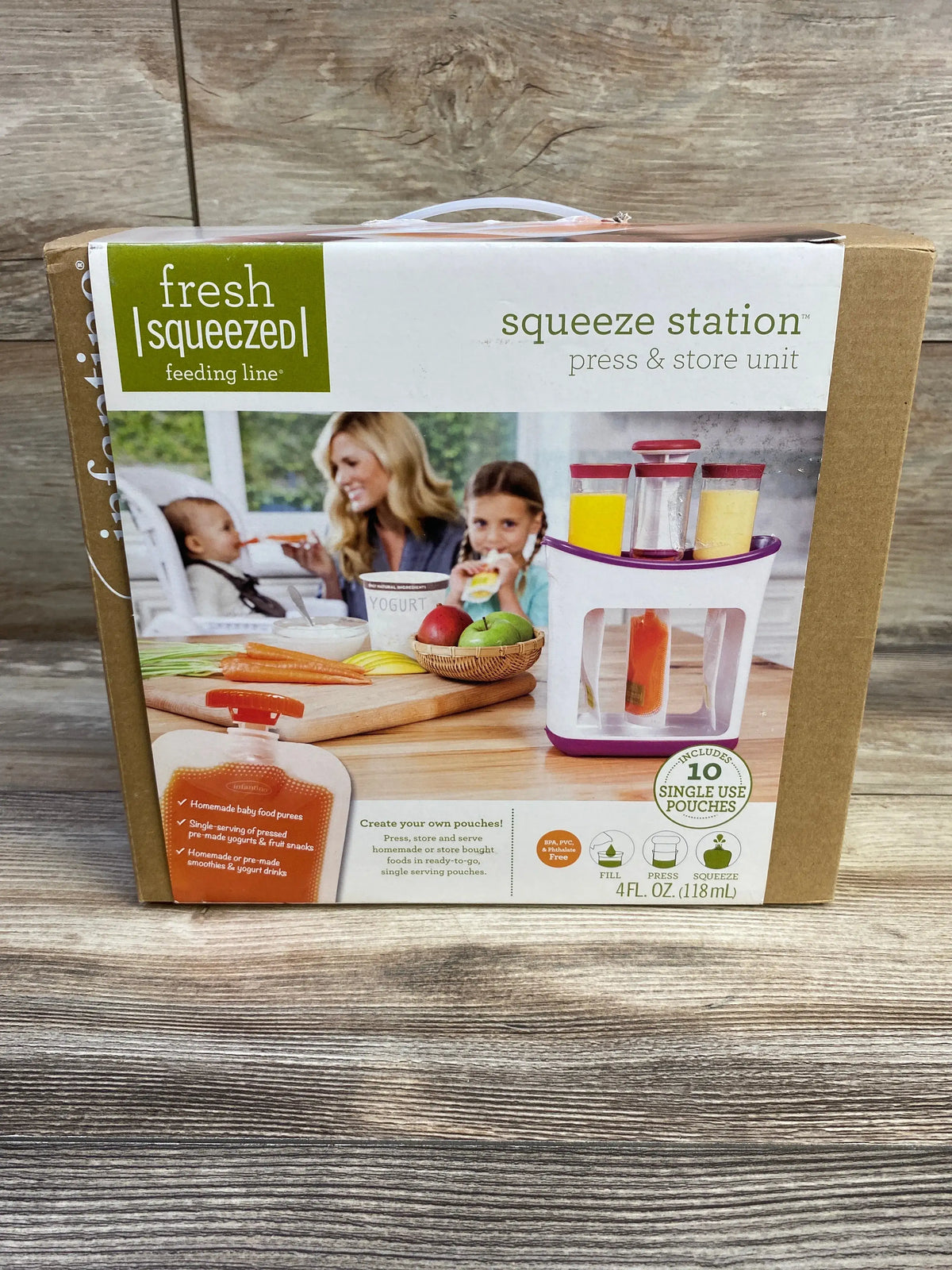 Front view of NEW Infantino Fresh Squeezed Squeeze Station box showing press and store unit with 10 pouches on wood-grain surface