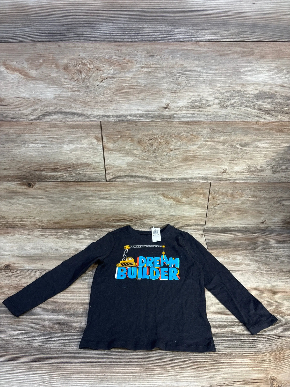 Black long sleeve kids shirt with 'Dream Builder' and crane graphic on wood background