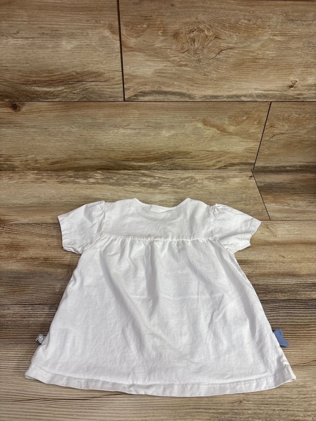 White Liegelind Whale short-sleeve toddler shirt for size 3T on a wood background