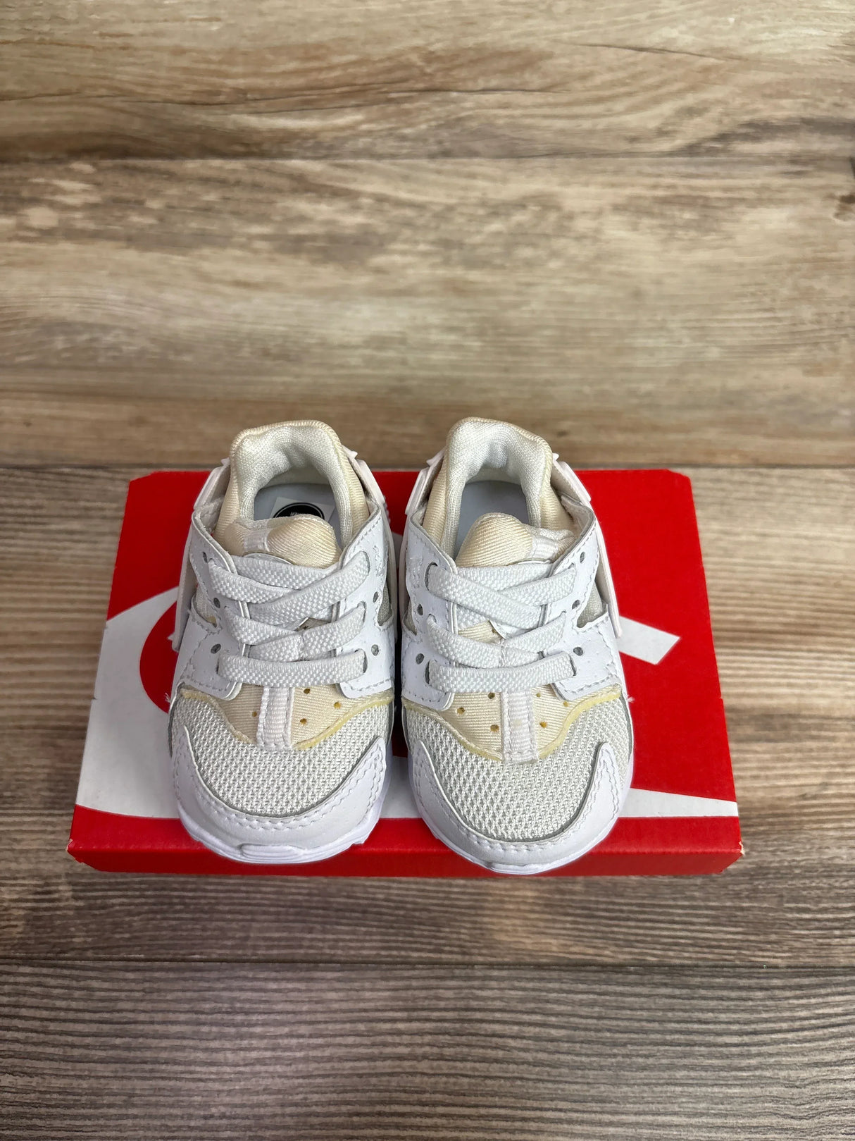 Top-front view of Nike Air Huarache toddler sneakers size 2C showing white mesh and leather upper on a red Nike box