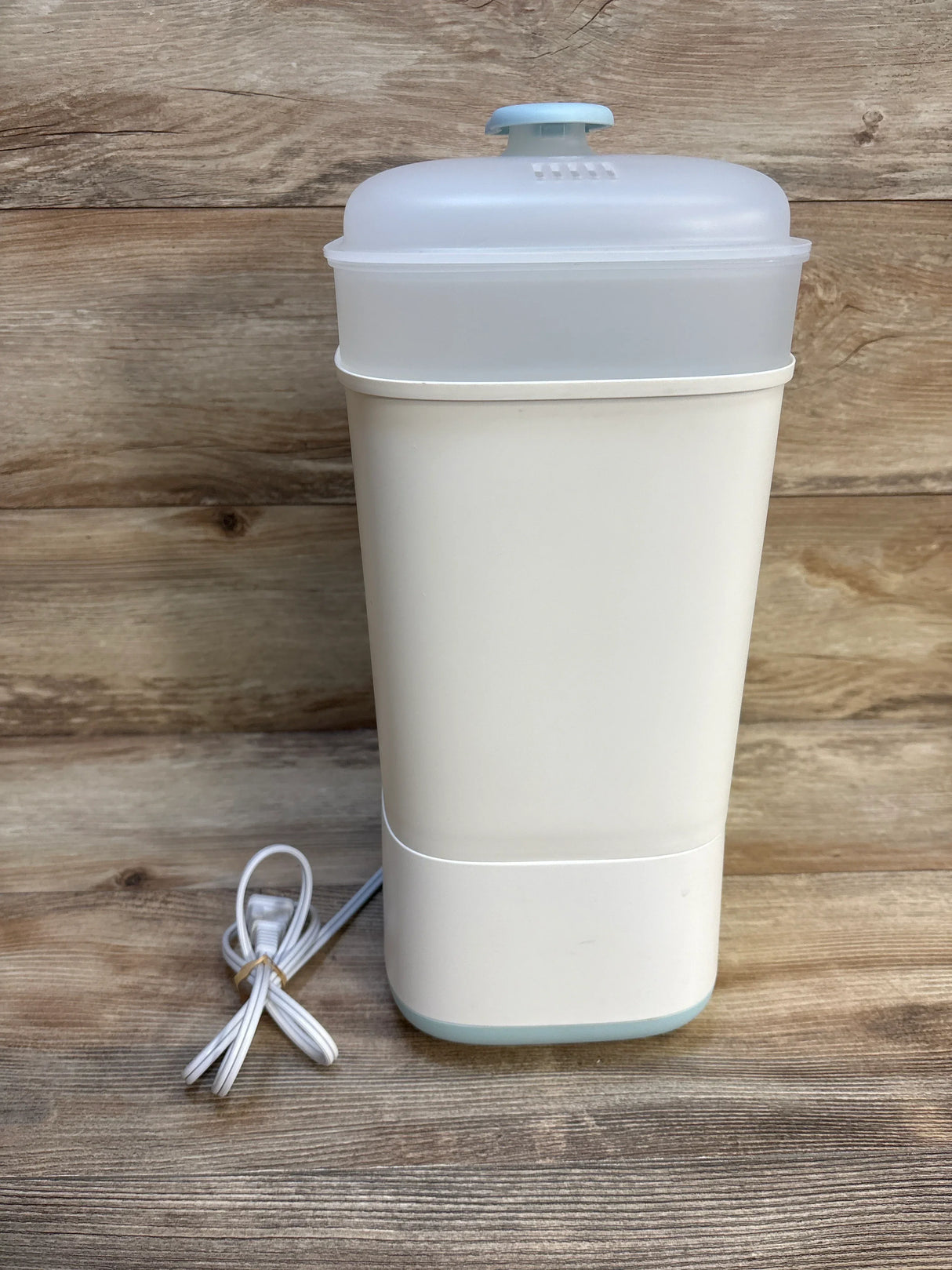 Front view of Papablic Baby Bottle Sterilizer and Dryer showcasing white upright sterilizer with frosted lid blue button and coiled power cord on wood plank floor