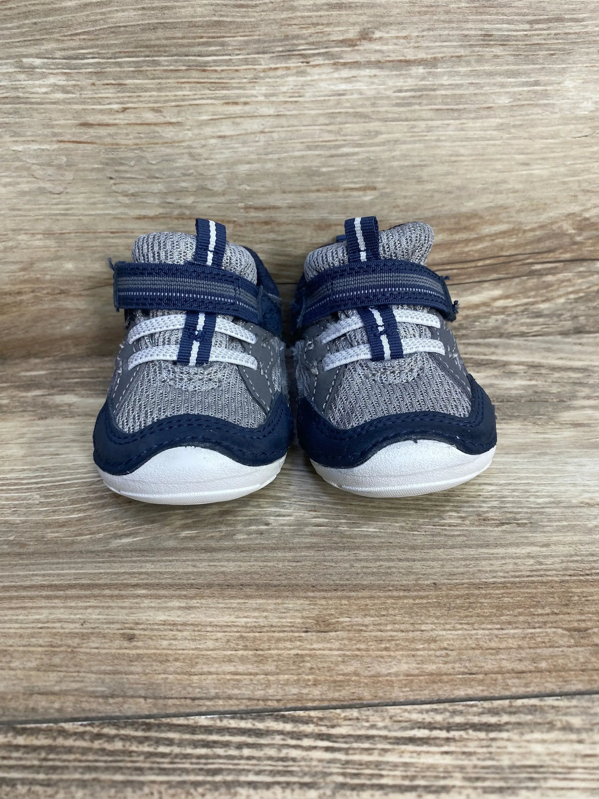 Side view of navy Stride Rite Soft Motion Kylo toddler sneaker showcasing hook-and-loop strap and cushioned sole on white background