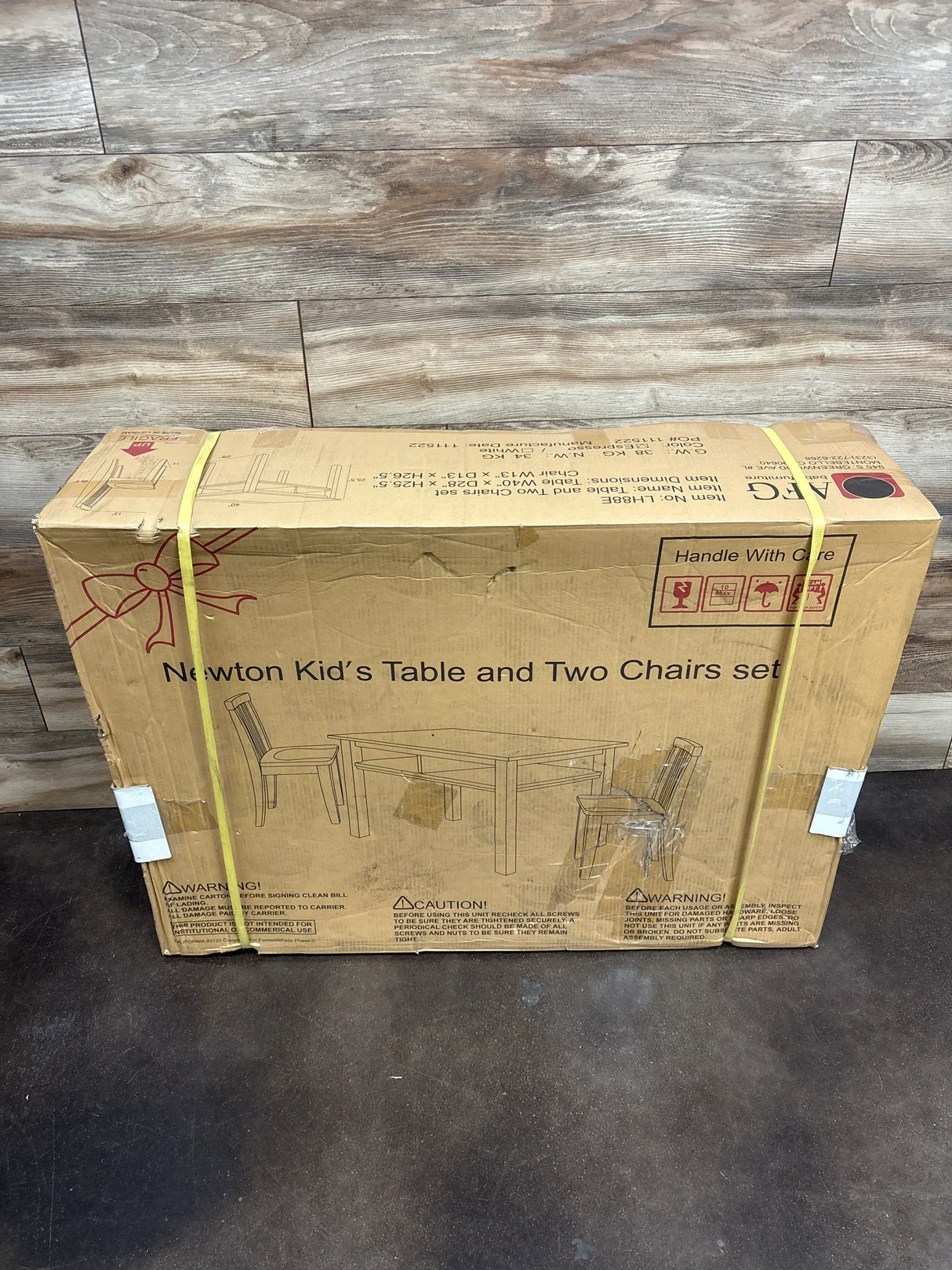 Newton kids table and two chairs set in box on wood floor, children's furniture.