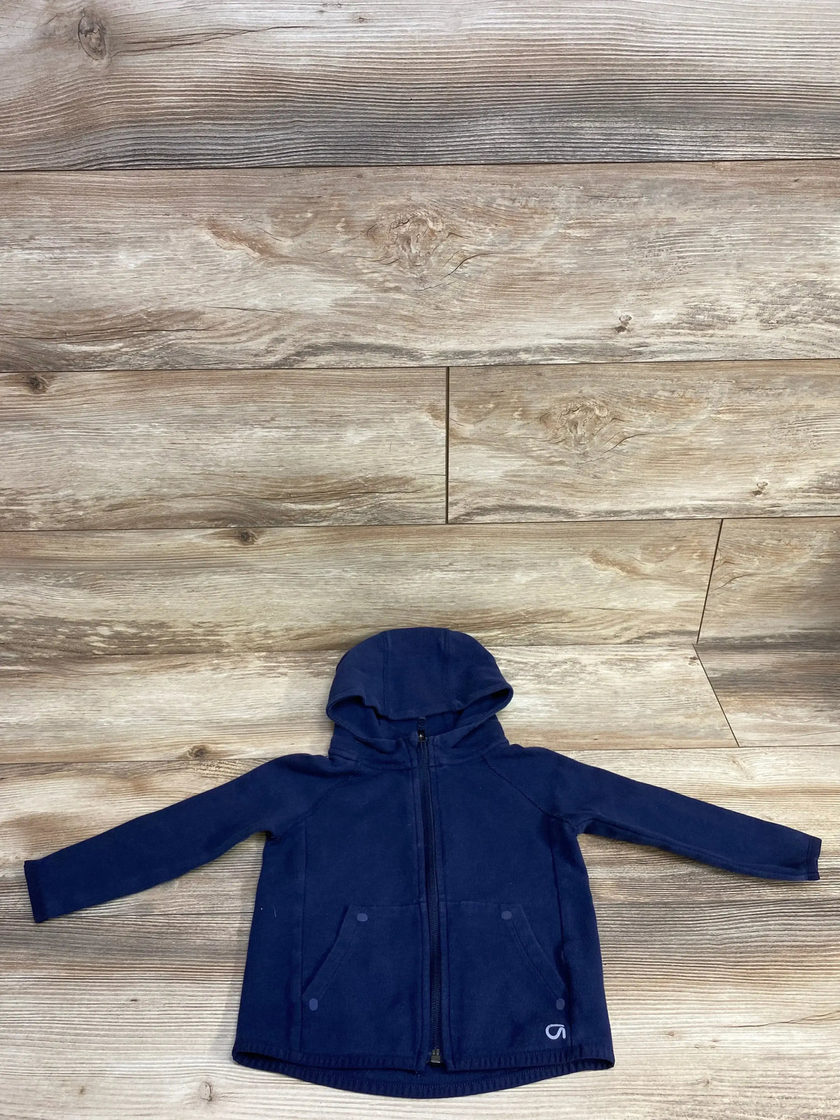Navy blue zip-up hoodie with front pockets on wooden floor background