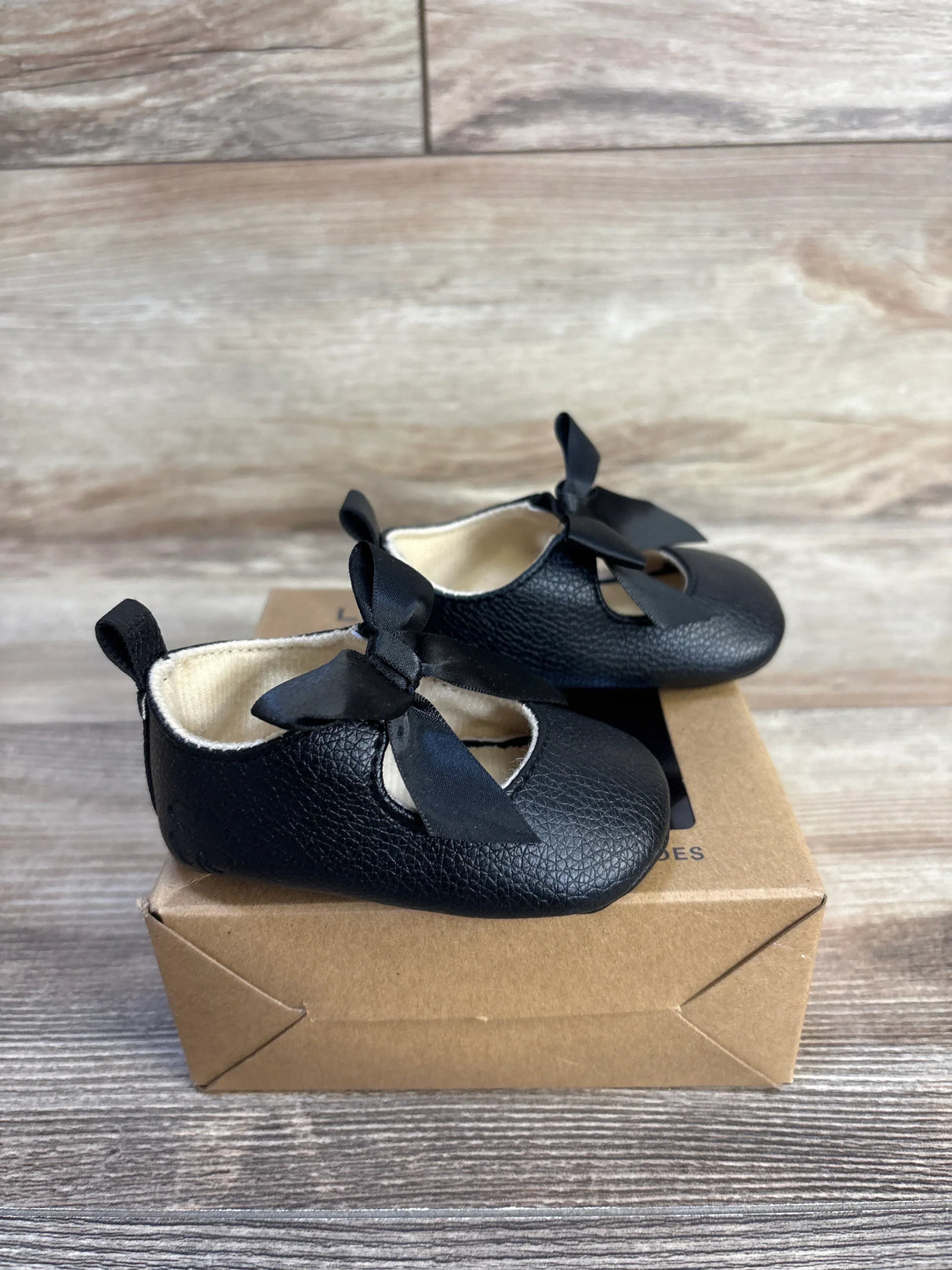 Black baby Mary Jane shoes with bows, soft sole, on box