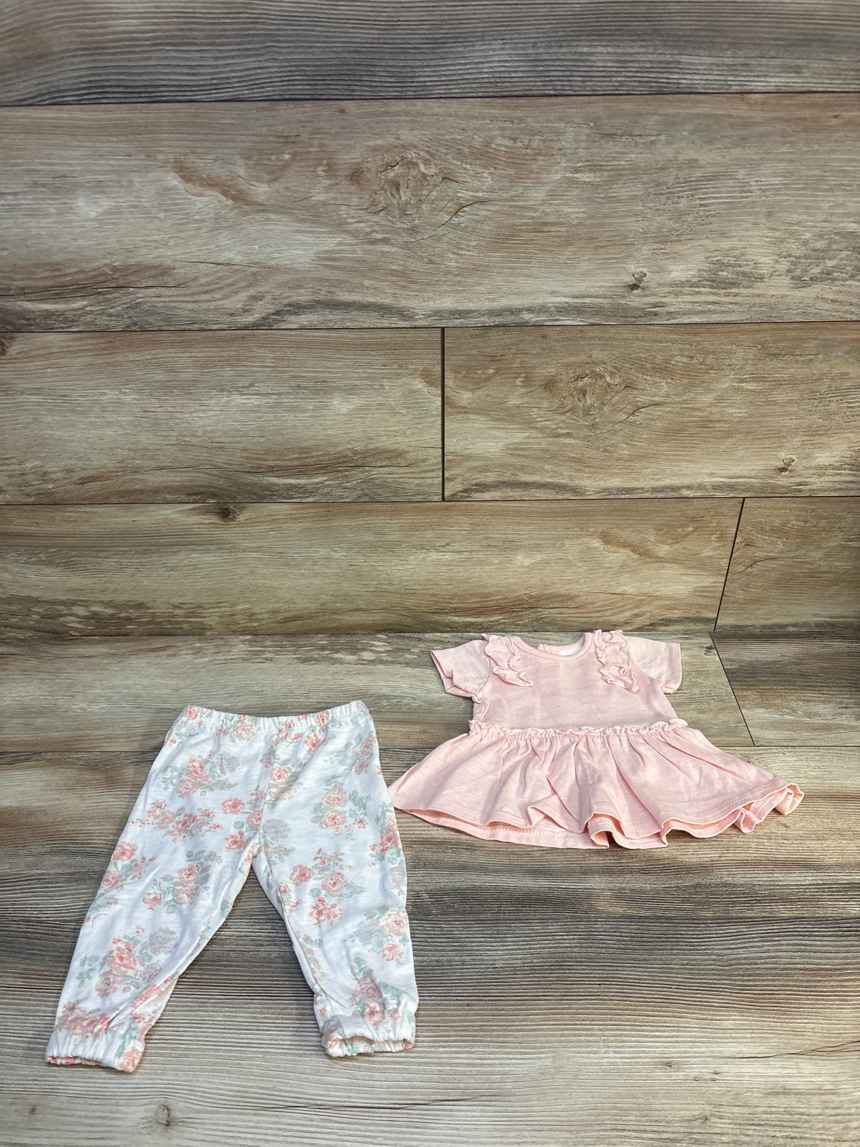 Pink baby dress and floral pants set on wood background, gently used kids clothes