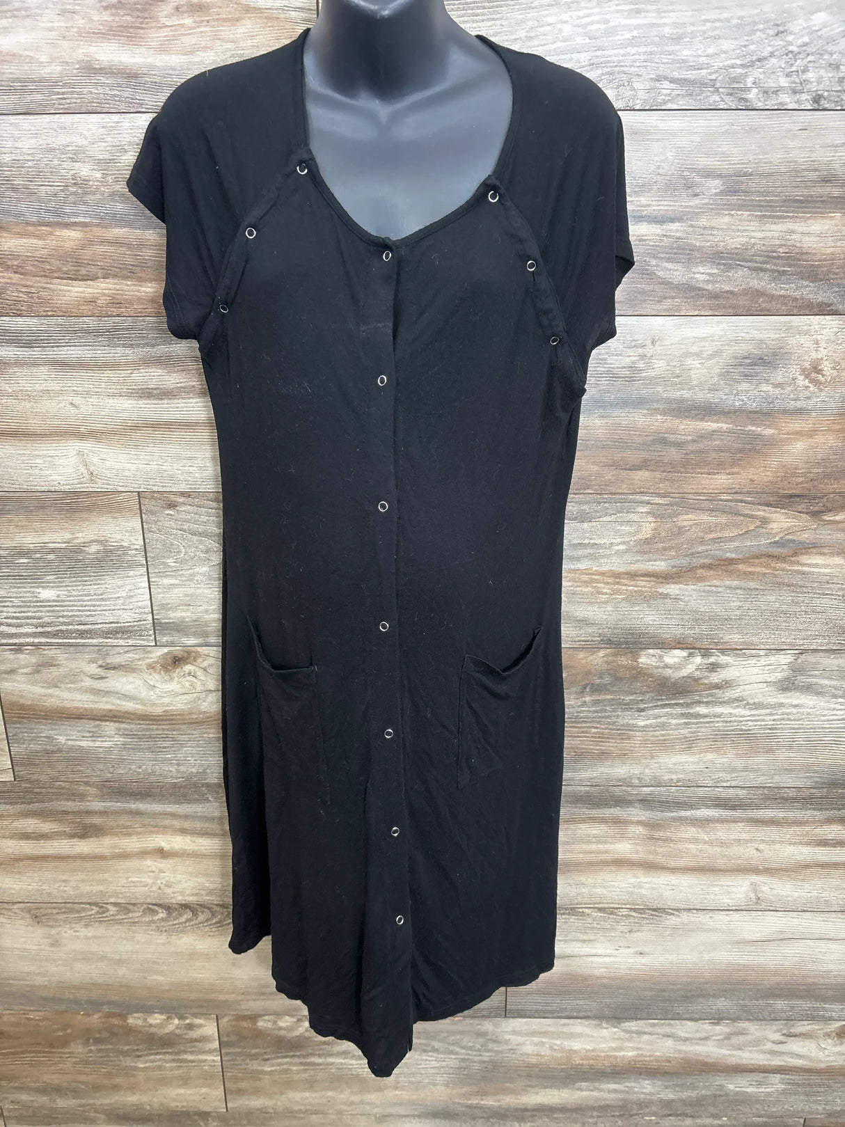 Black button-front maternity dress with short sleeves and side pockets on mannequin