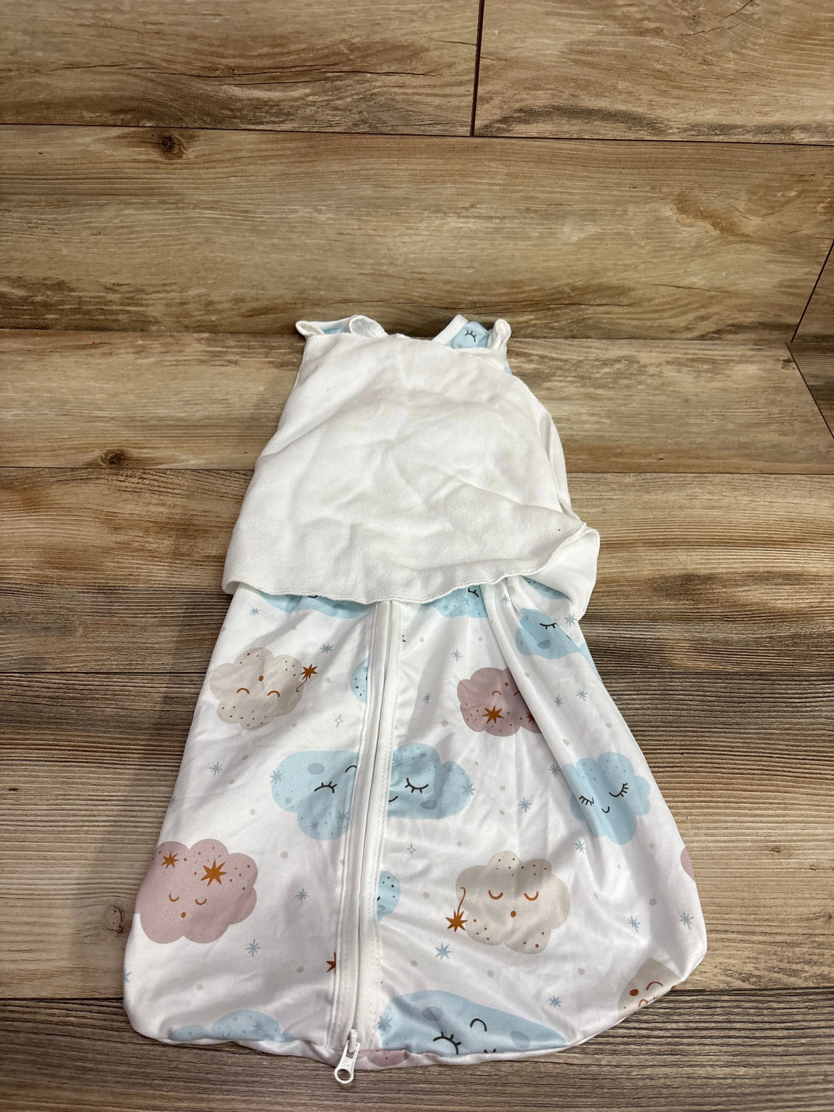 Front view of white BSTOPPT 3-Way Adjustable Sleep Sack Swaddle showcasing front zipper and cloud print on wood