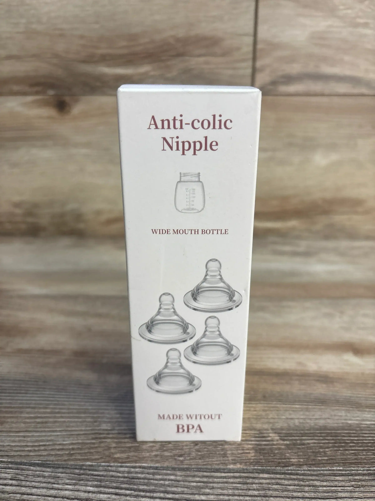 Anti-colic wide mouth baby bottle nipples made without BPA on wood background