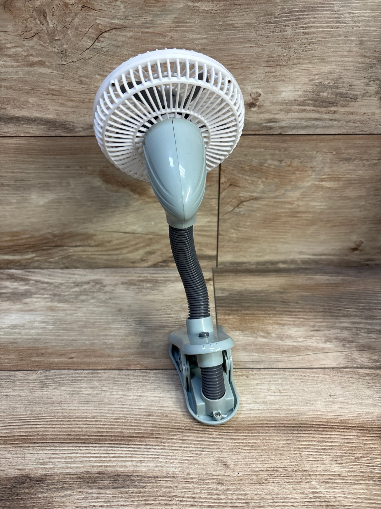 Front view of O2COOL 4-inch clip-on stroller fan showcasing flexible gooseneck and clamp base on wood background